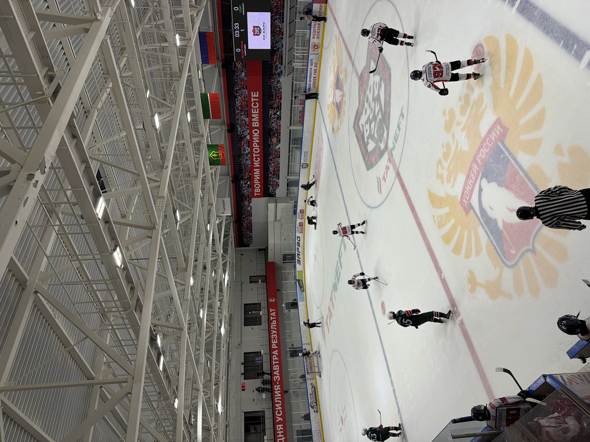 Hockey game underway at Almetyevsk arena with corporate sponsors