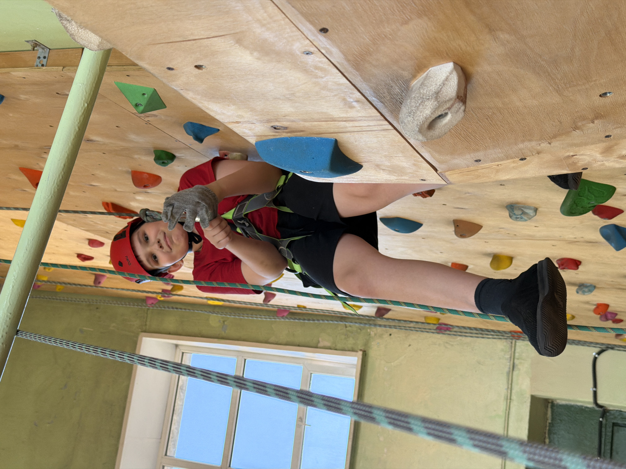 Child practices indoor rock climbing in Izhevsk gym