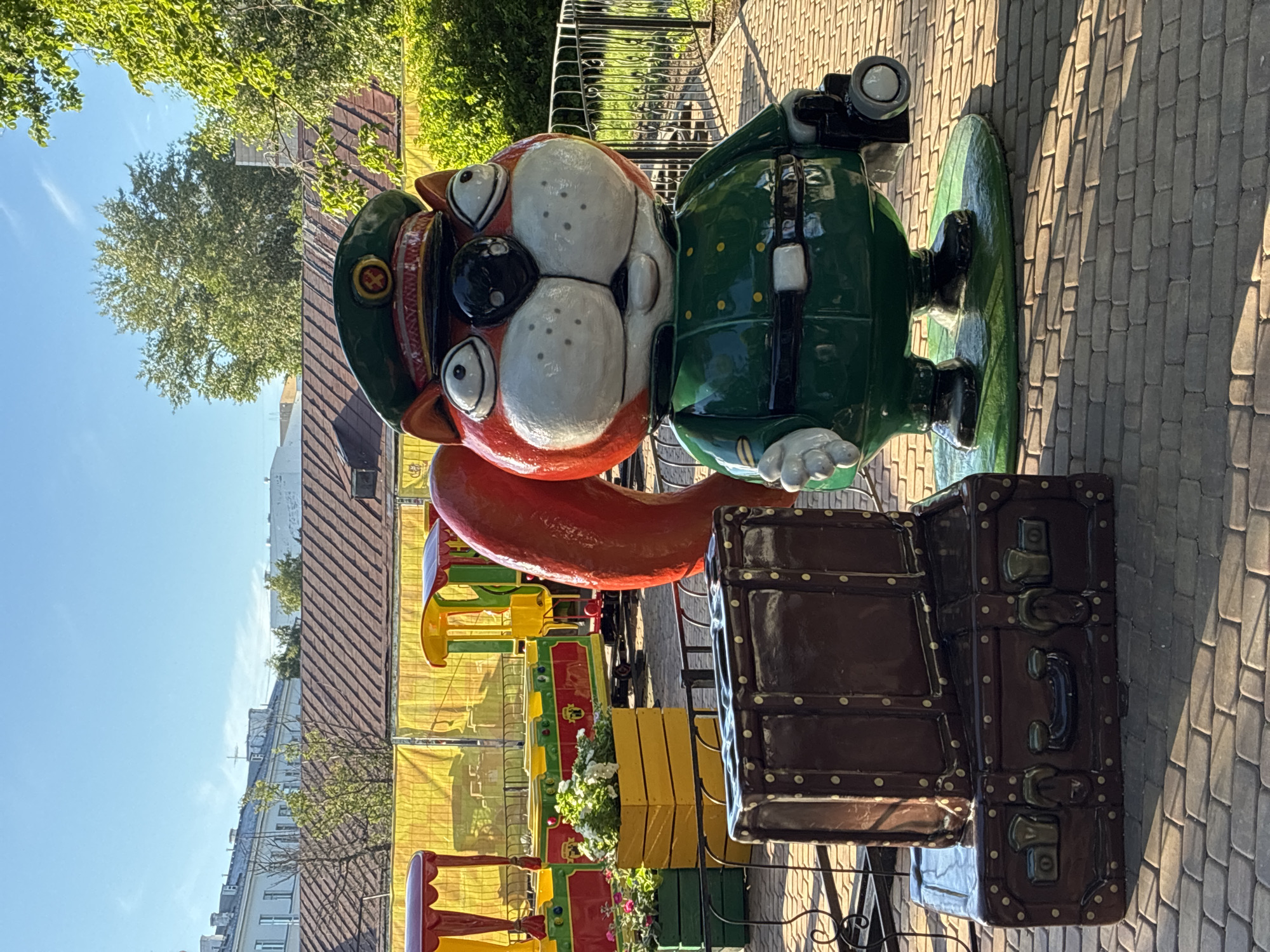 Miniature train and Ferris wheel at a sunny park amusement area