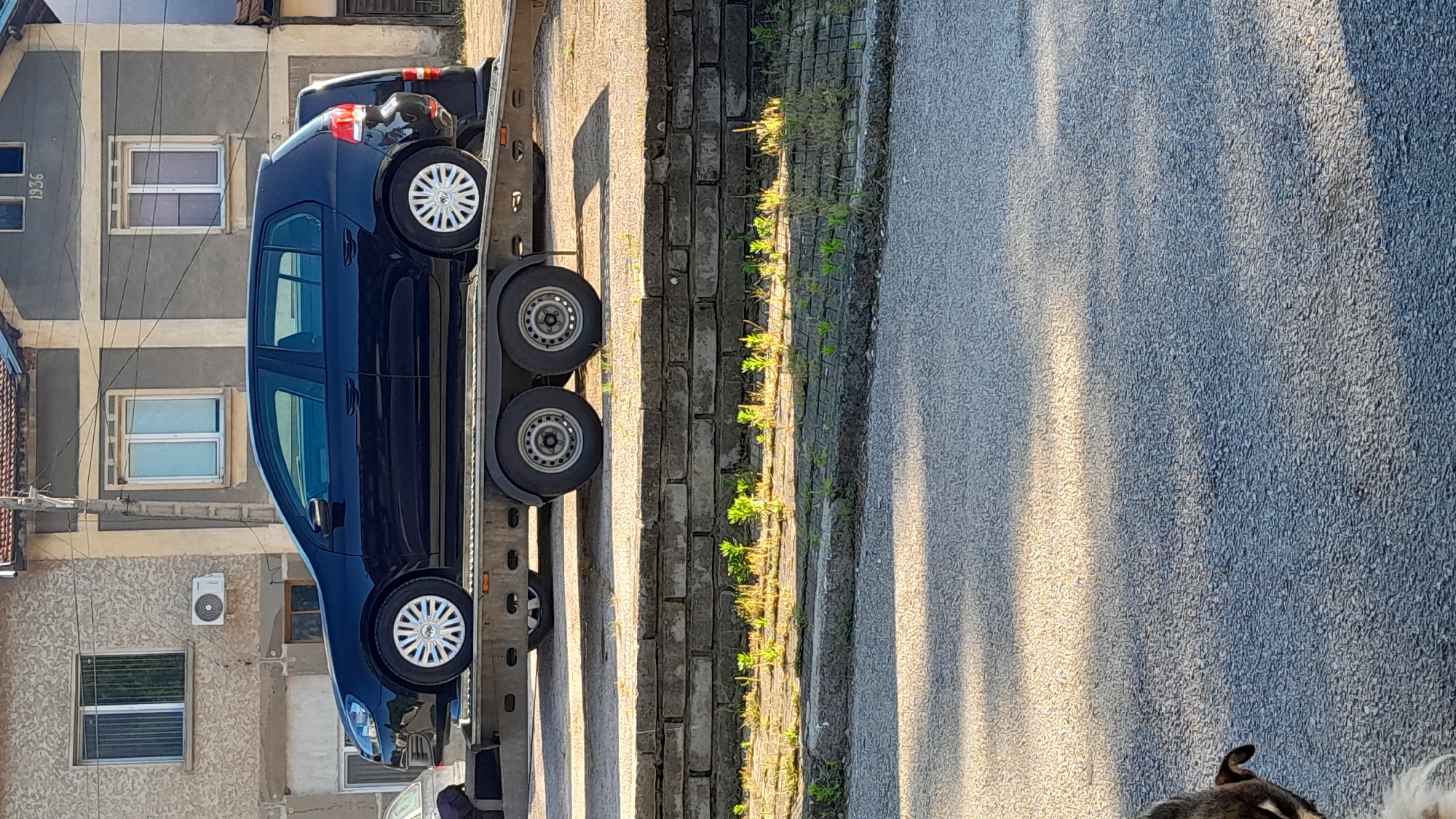Blue Volkswagen Golf spotted on car transporter near stone wall