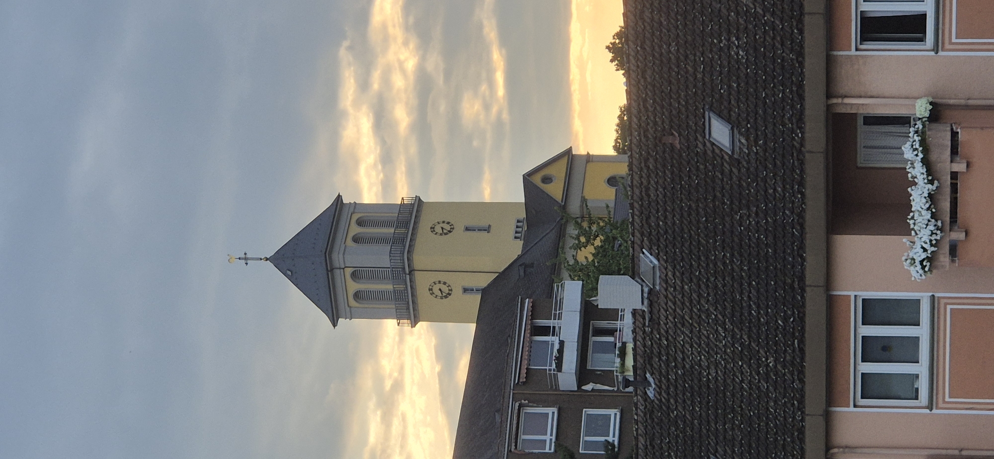 Yellow church tower with twin clock faces, Mainz