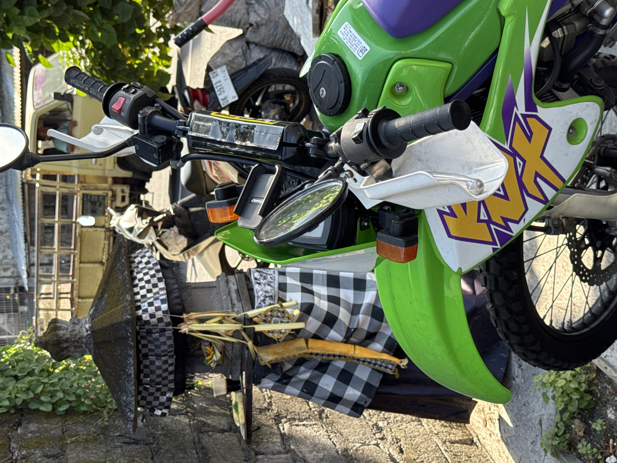 Indonesian coconut vendor prepares fresh coconuts near decorated motorcycle