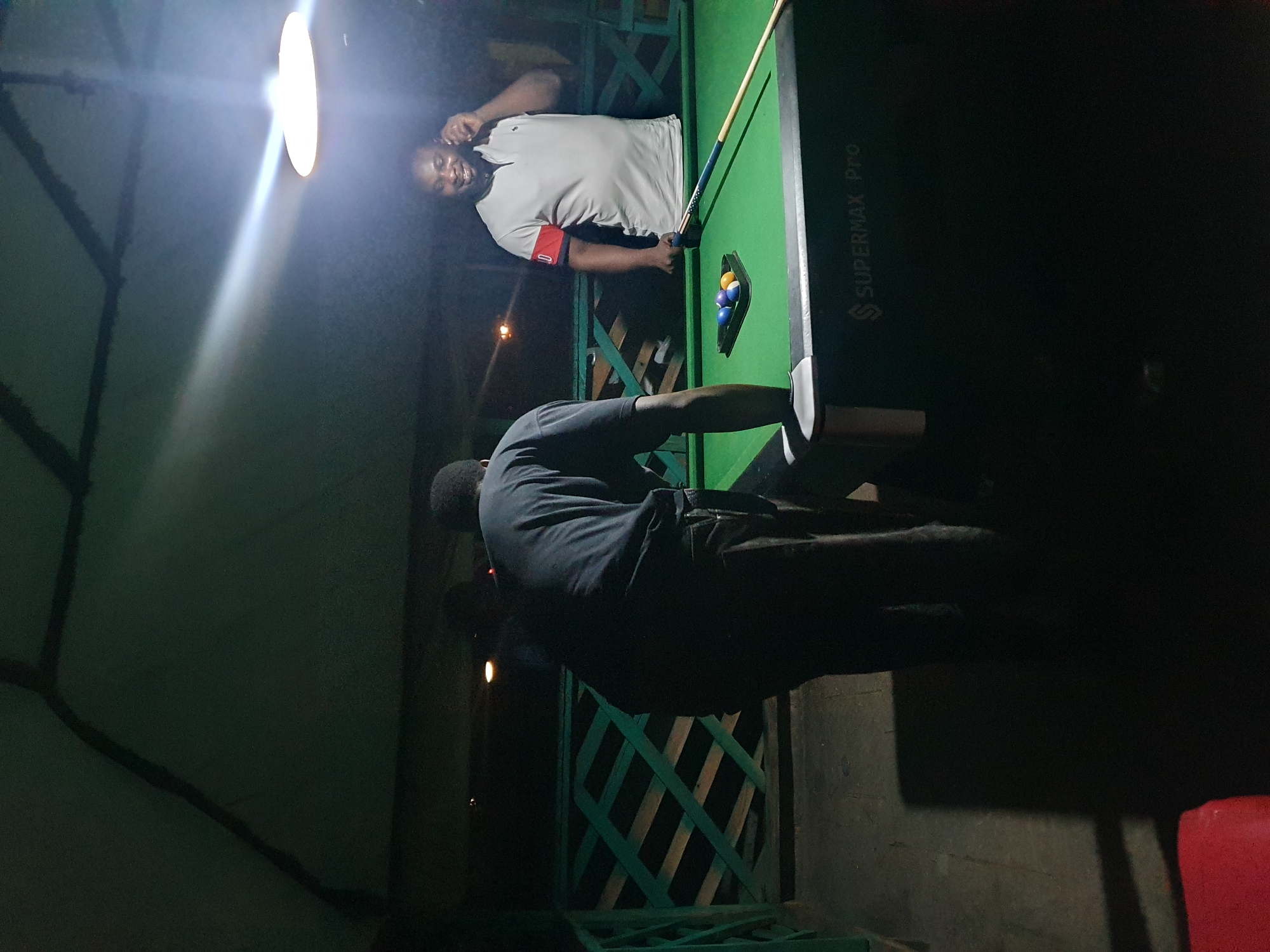 Men play evening pool at outdoor venue in Lokoja