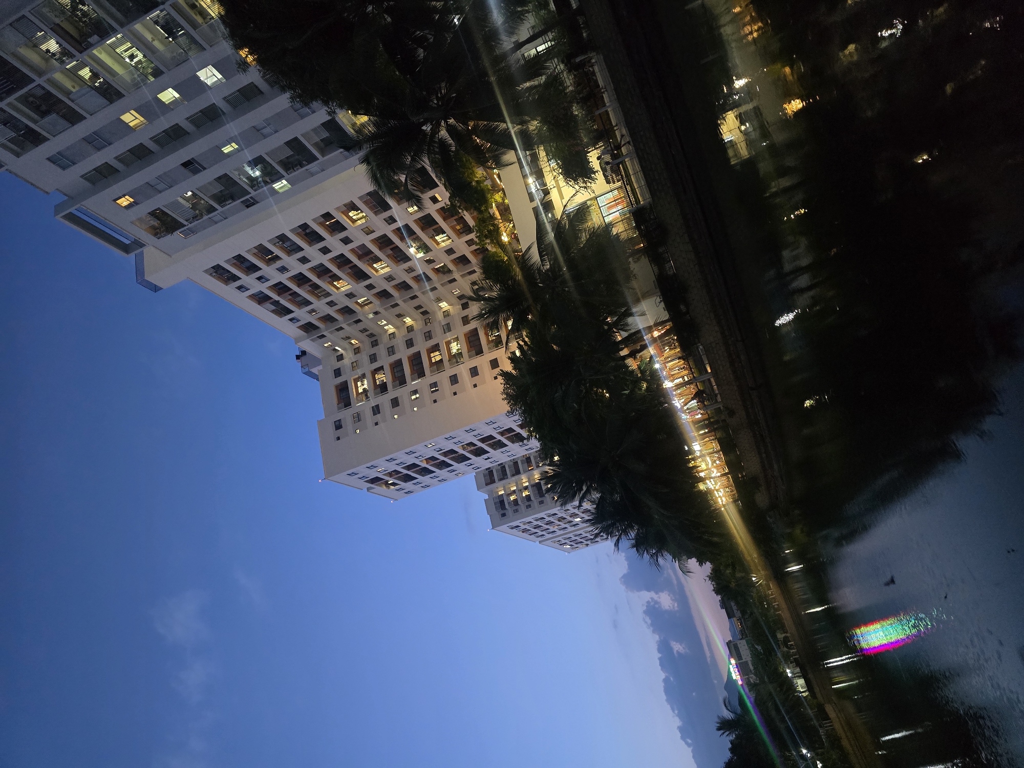 Nha Trang at night: apartment towers and lantern-lit garden seating