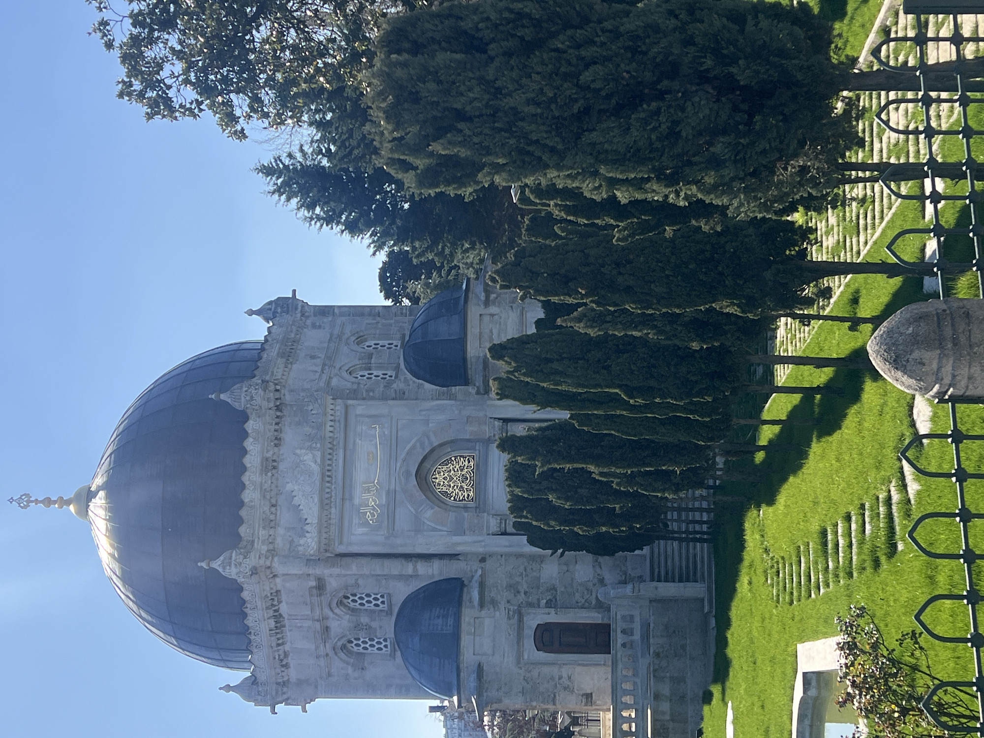 Stone mausoleum with golden dome documented in grassy area