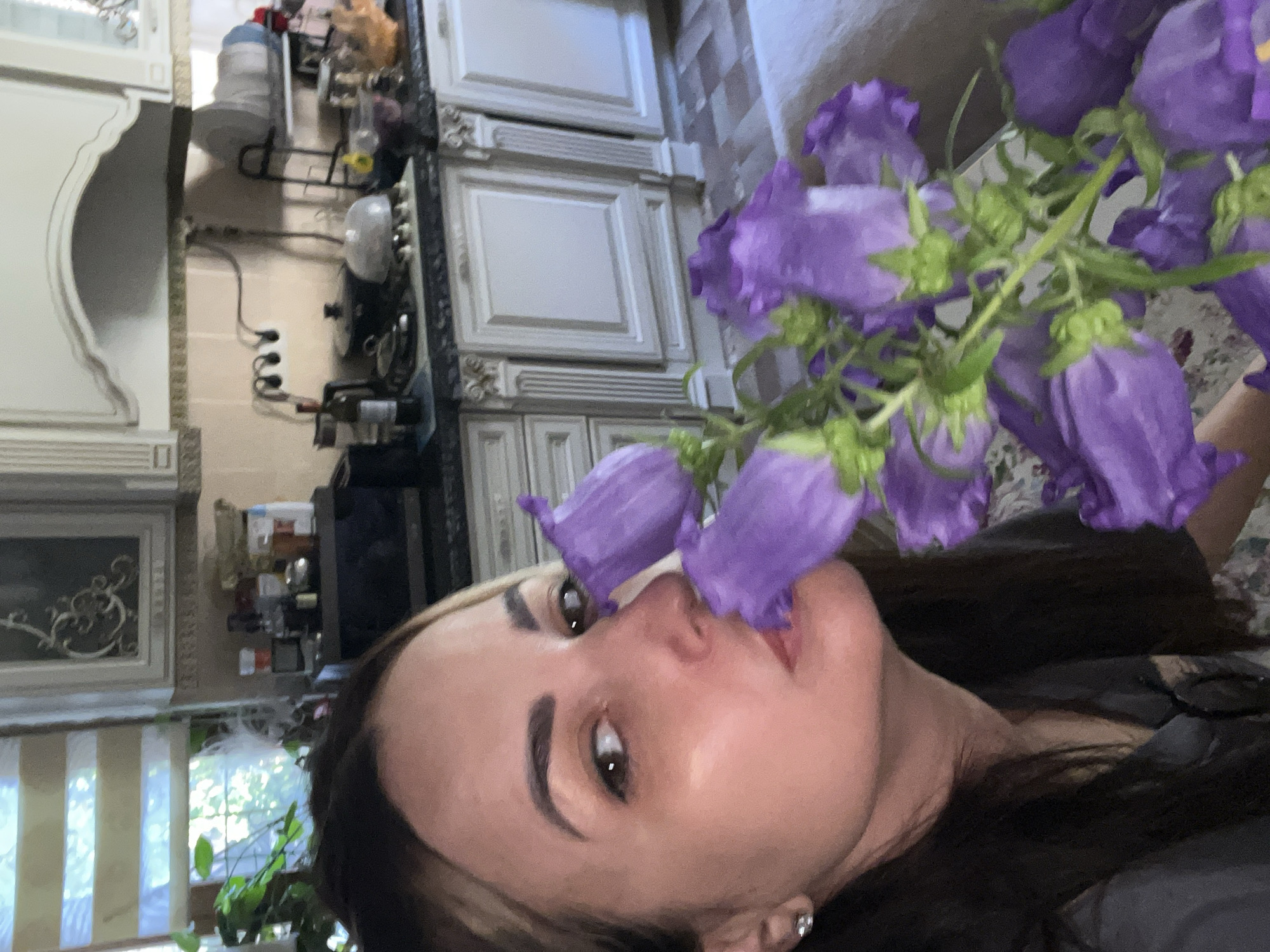 Woman documents morning moment with flowers in home selfies