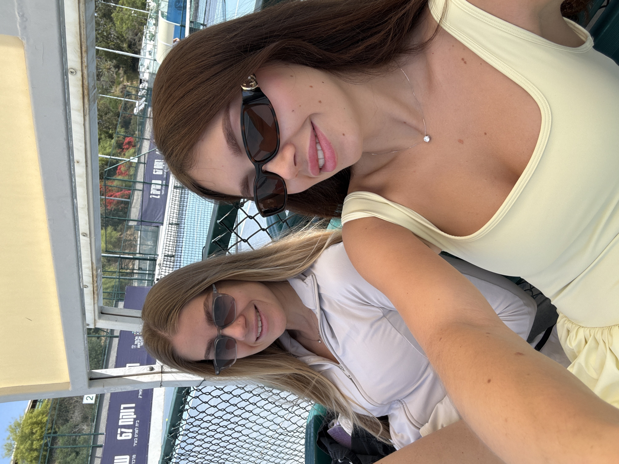 Two women sit by tennis court in Tel Aviv