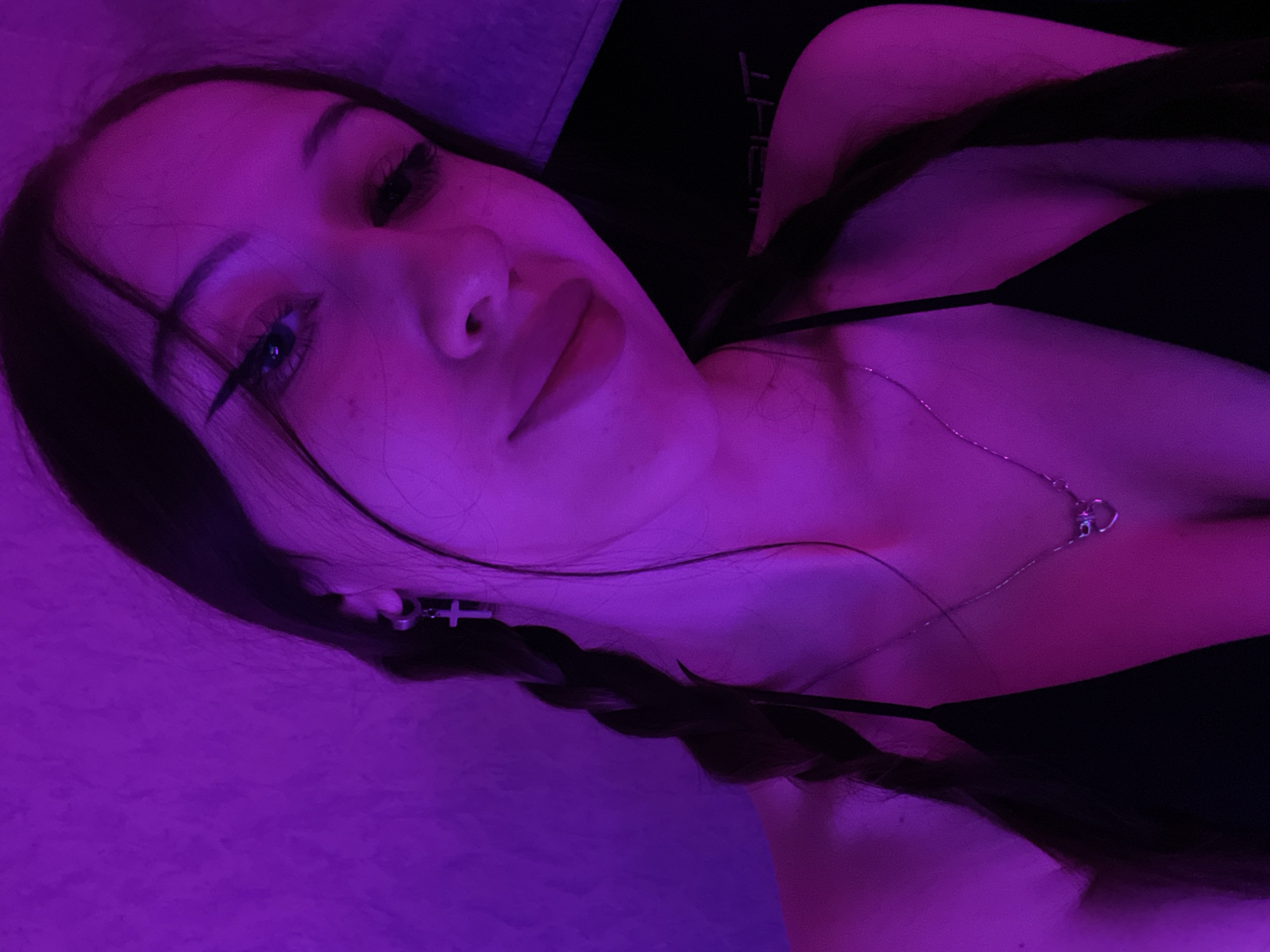 Woman documents evening selfie session in purple-lit bedroom in Votkinsk