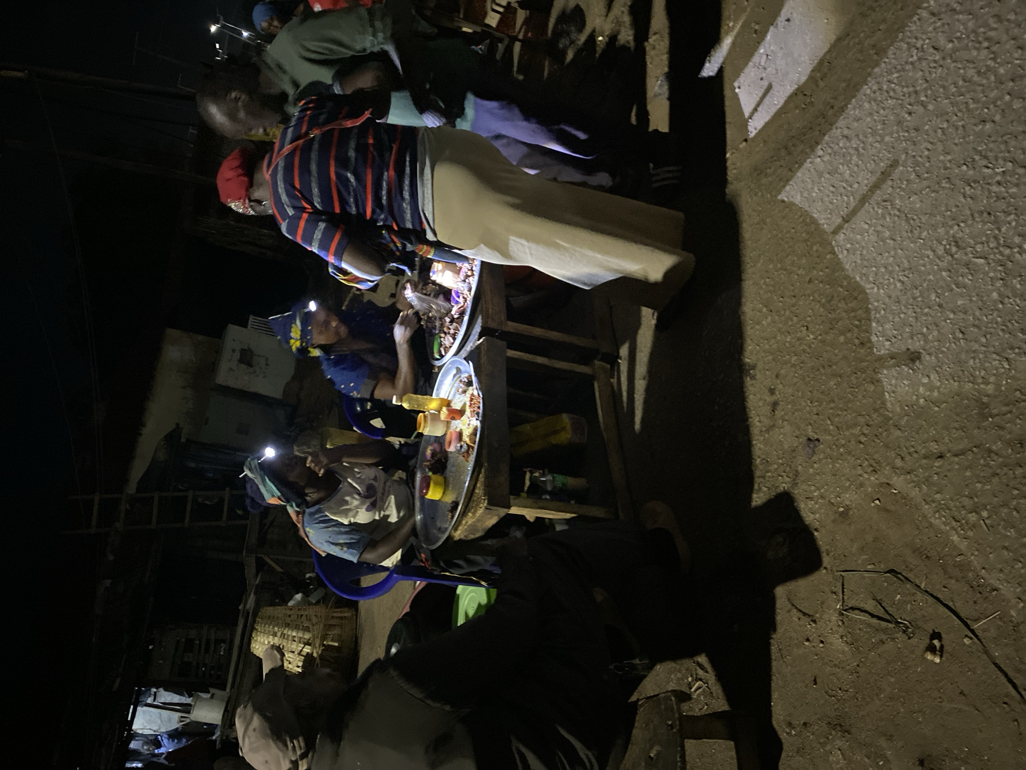 Night market vendors serve street food in Bukuru, Nigeria