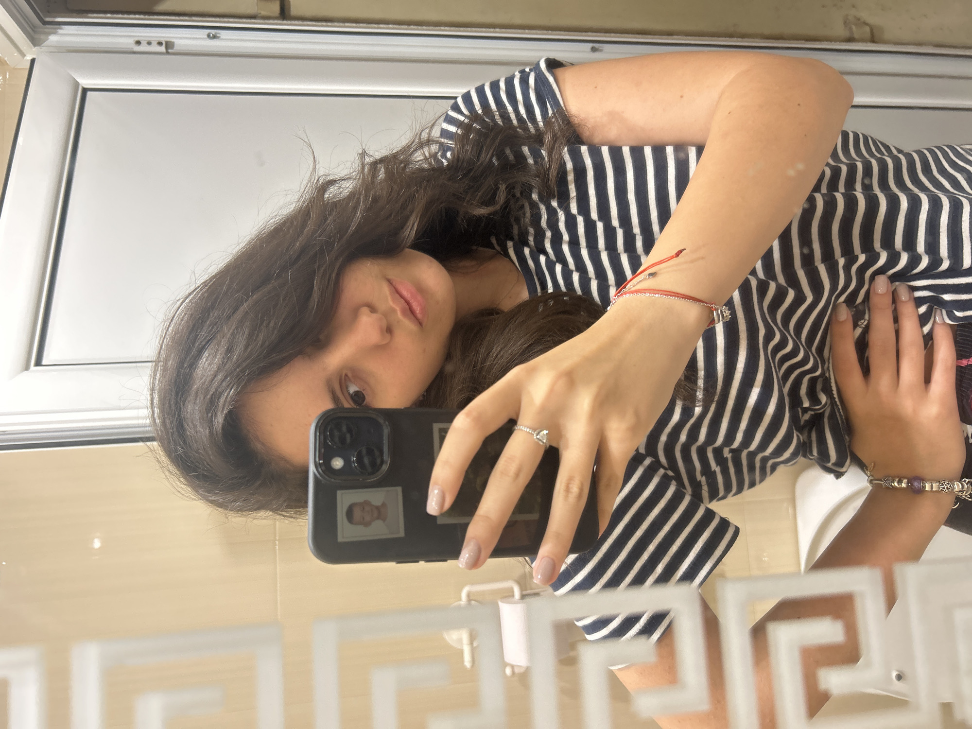Woman takes bathroom selfie with photo-decorated phone