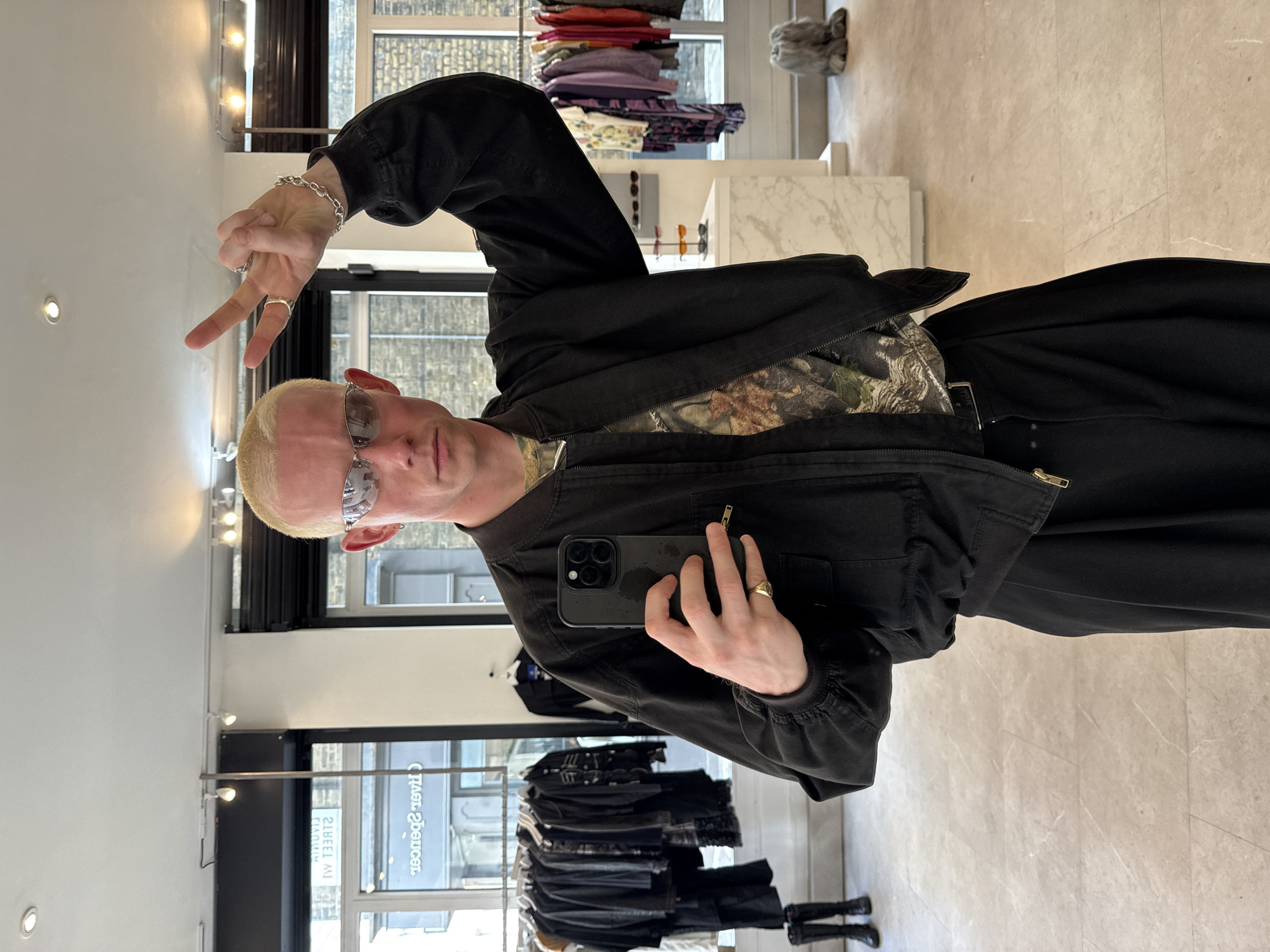 London shopper takes mirror selfie, street scene captured nearby