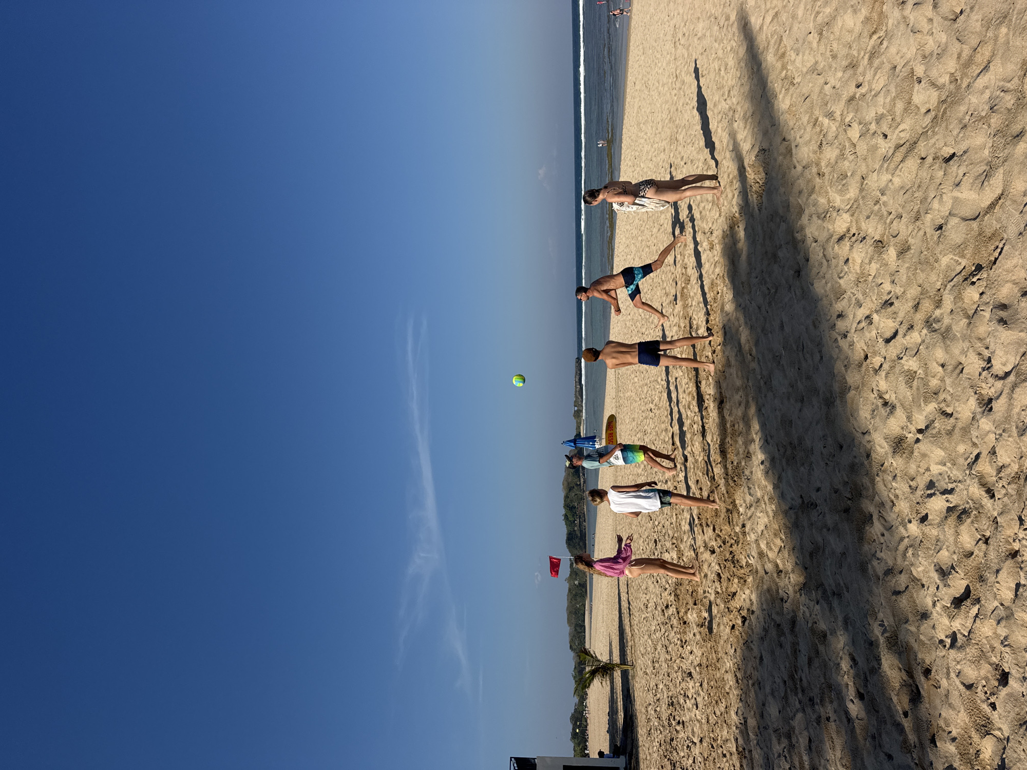 Beach morning in Kuta Selatan: surf, sand, and a lotus pond nearby