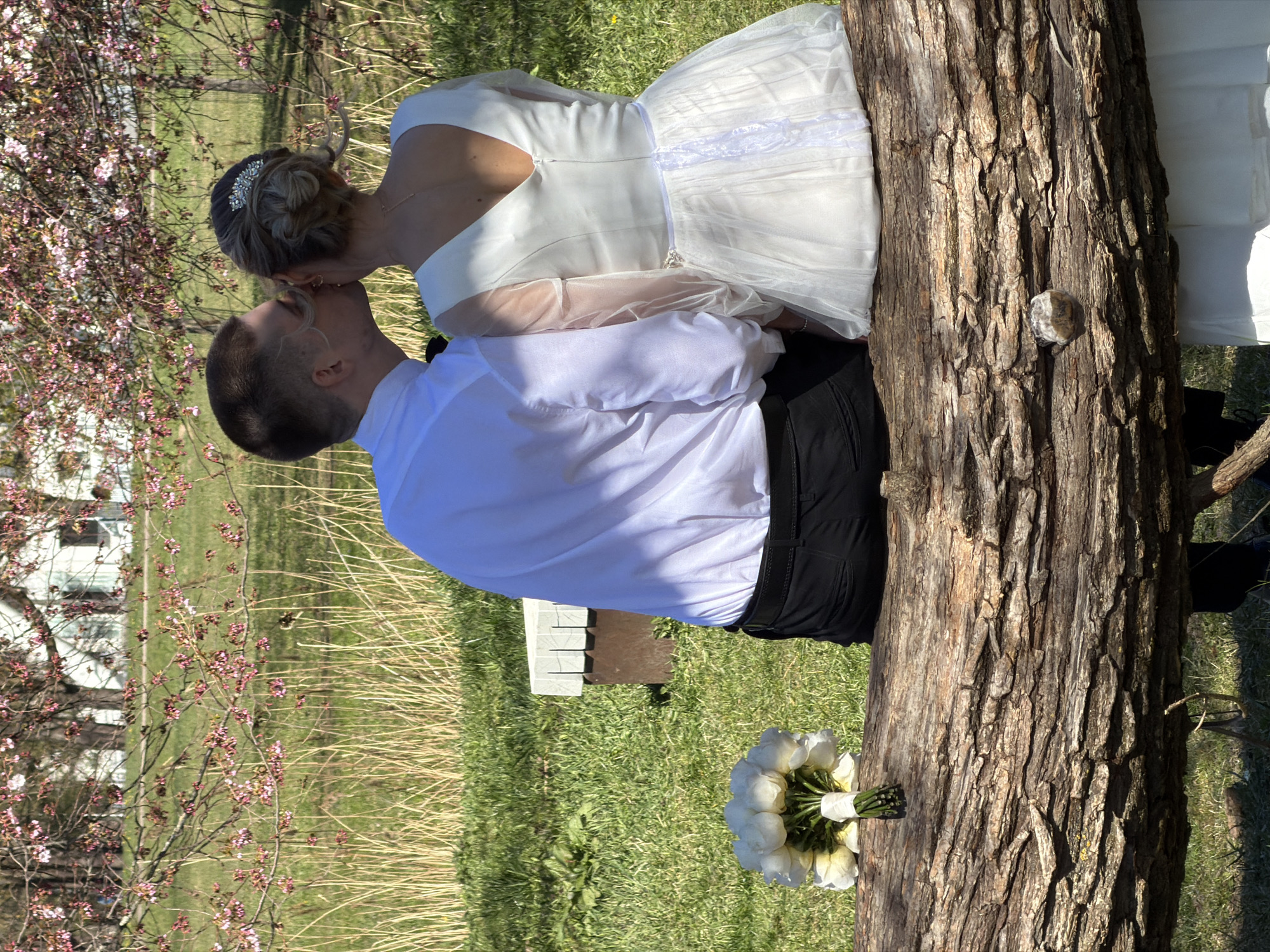 Newlyweds Kiss Outdoors in Wedding Portrait in Riga