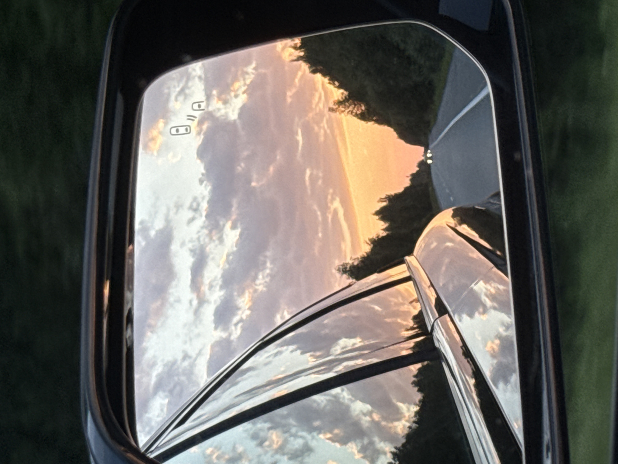 Sunset reflected in a side mirror on a Russian road