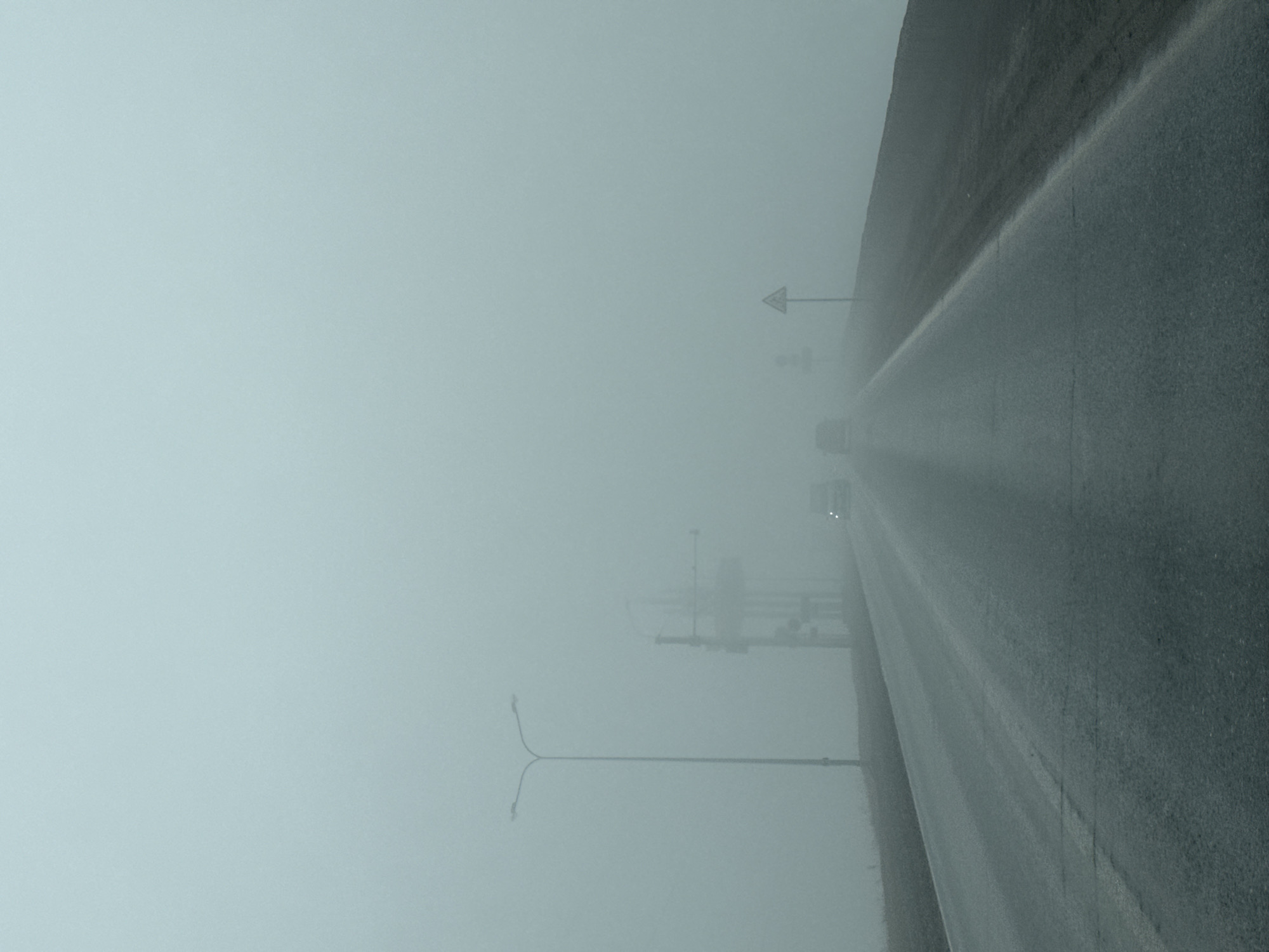 Dense fog blankets wet roadway in Chaikovsky, Russia