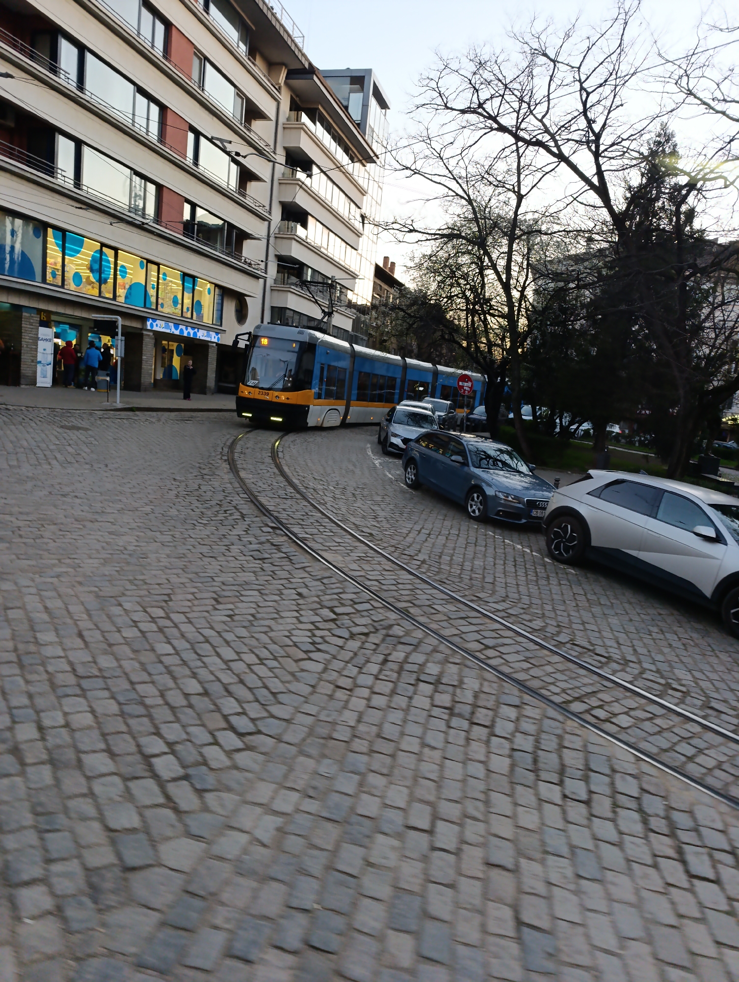 Tram navigates cobblestone street in historic Sofia district