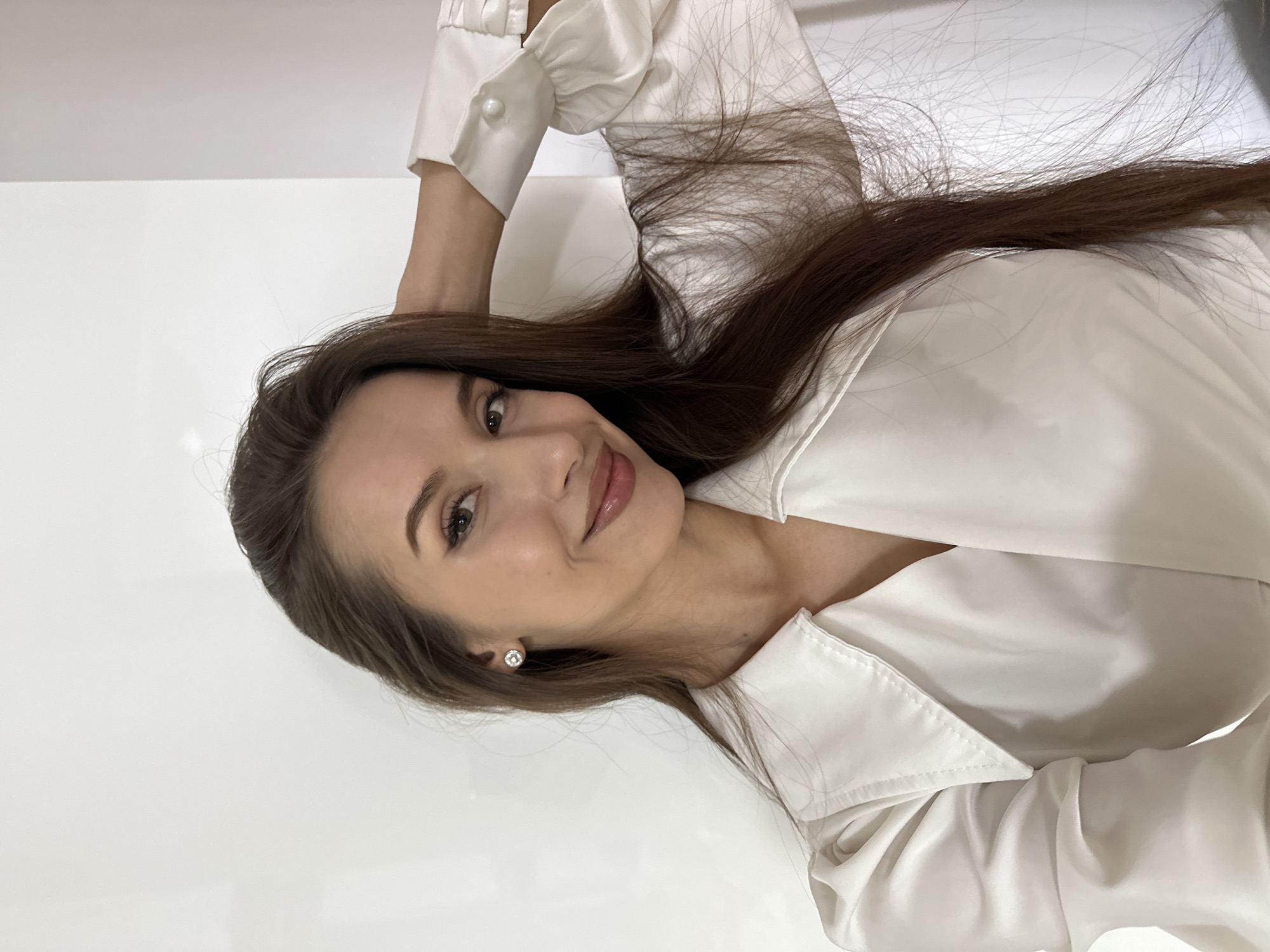 Woman takes mirror selfies in white blouse in Yekaterinburg