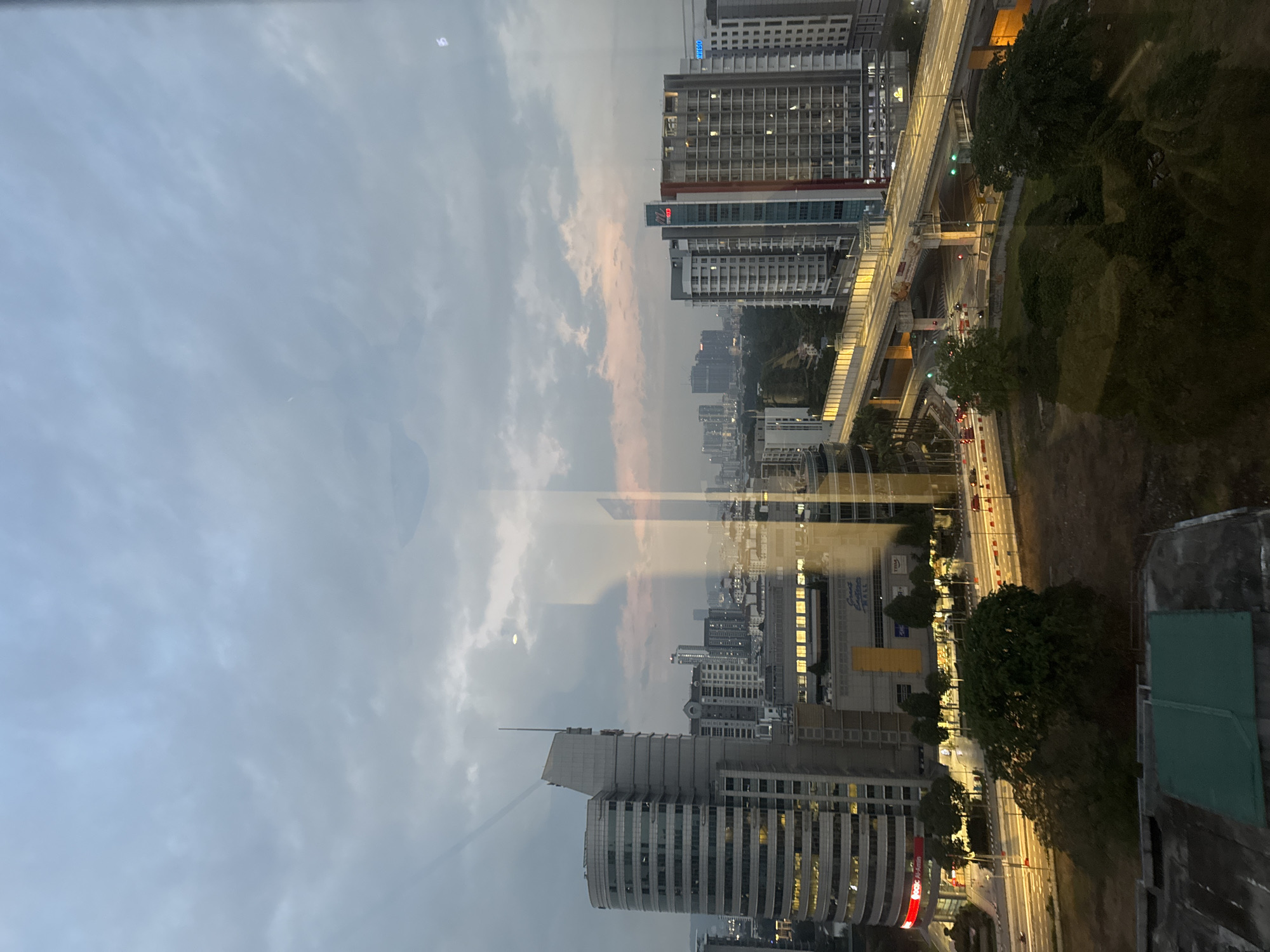 Kuala Lumpur skyline at dusk through a high-rise window