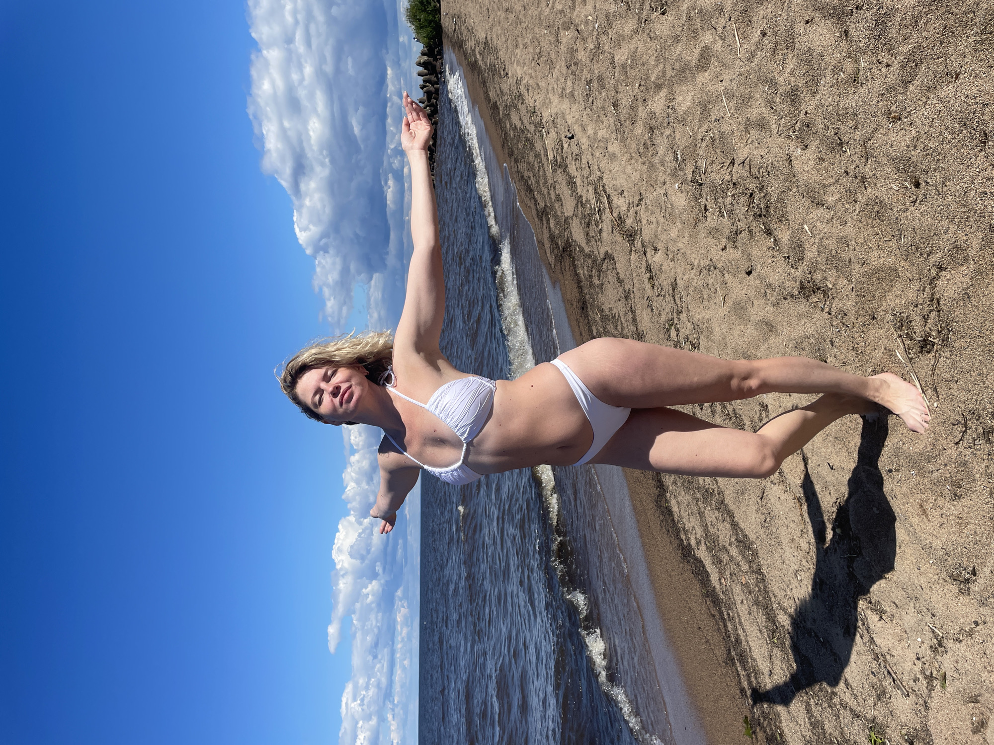 Beach morning on a Russian shoreline, arms up, waves rolling in.