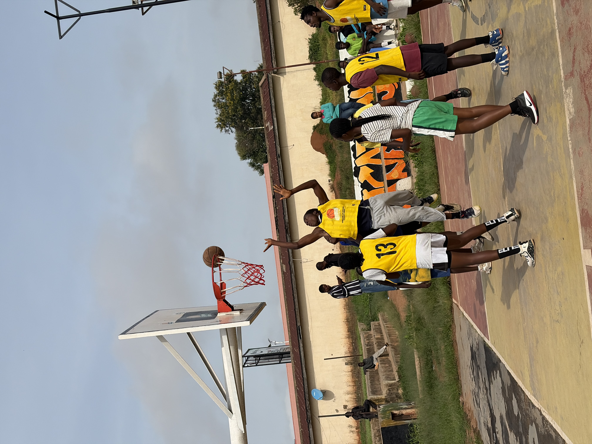 Pickup basketball on a worn outdoor court in Jos, Nigeria