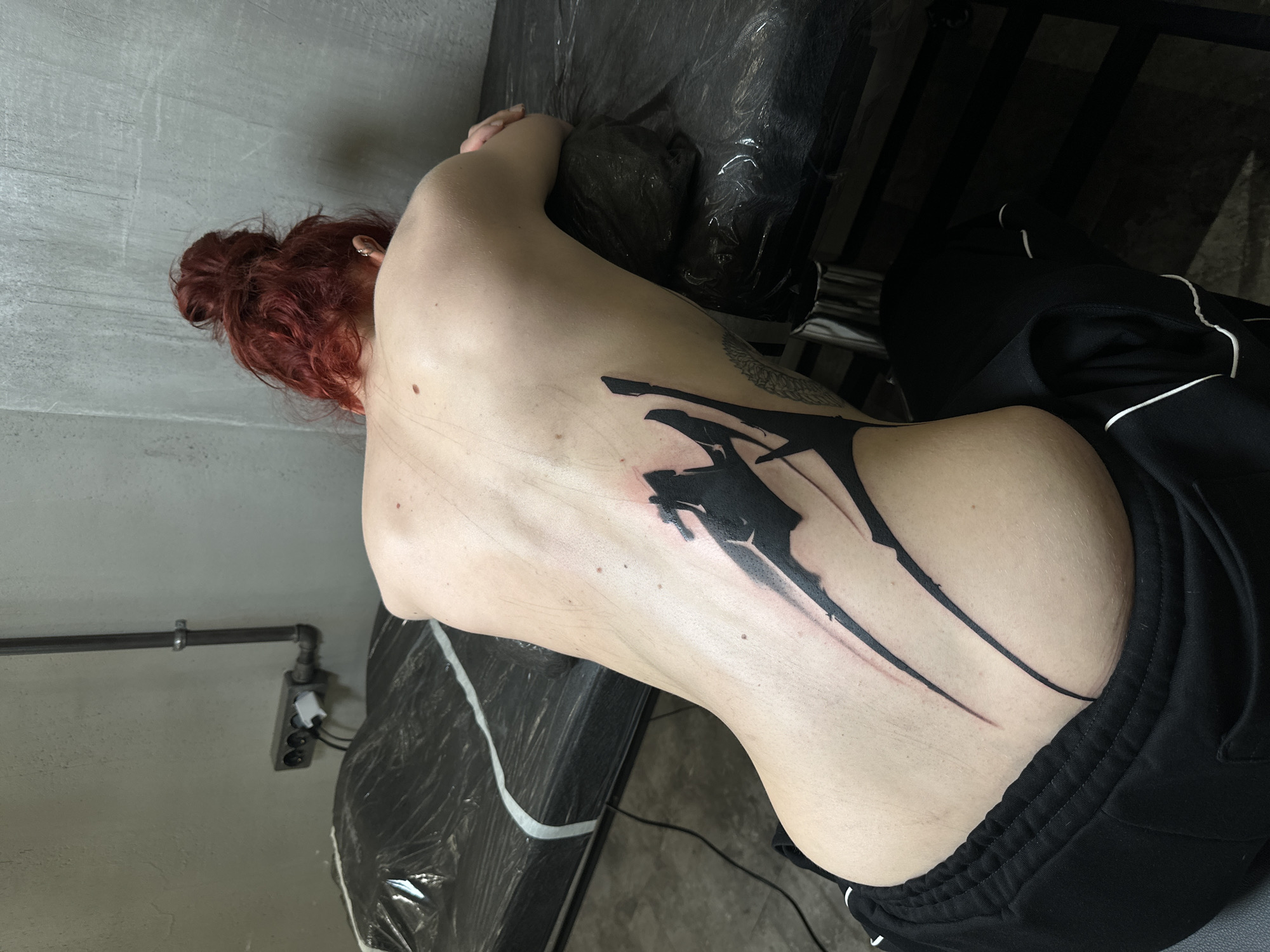 Woman gets abstract back tattoo at Moscow parlor