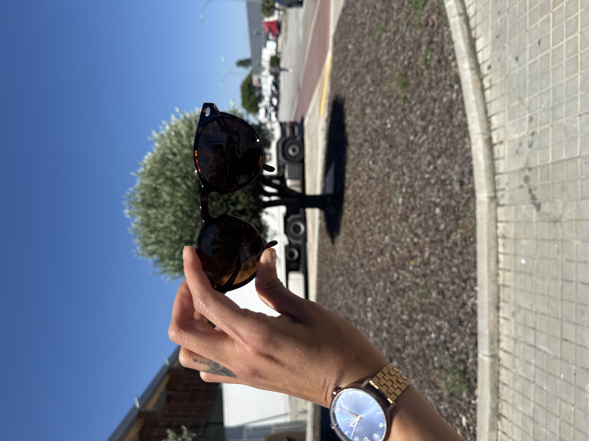 Person tries on sunglasses near racing car in Barcelona