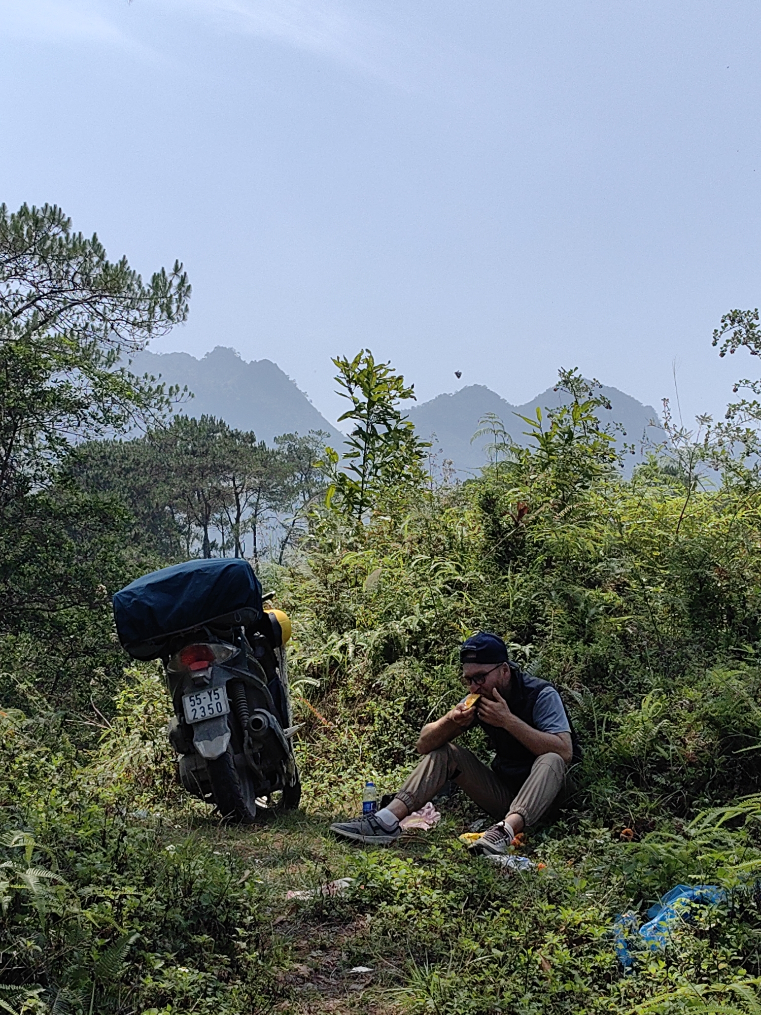 Solo motorcyclist takes roadside break in Vietnam mountains