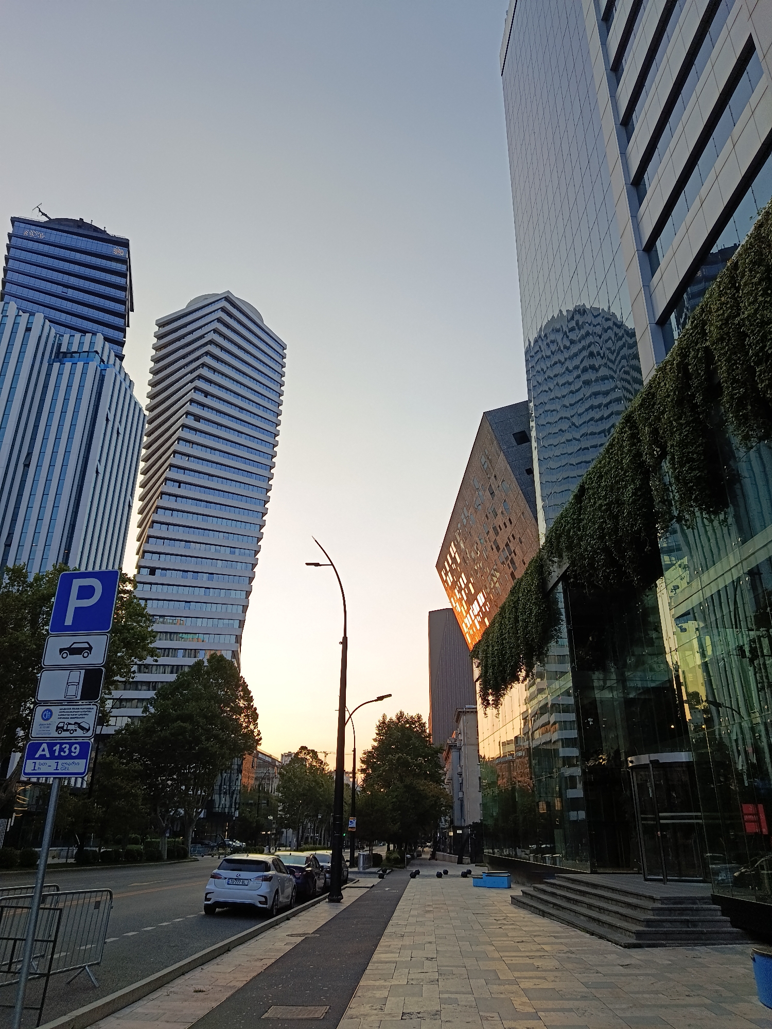 Glass towers, a bronze statue, a perfume shop, and dusk streets.