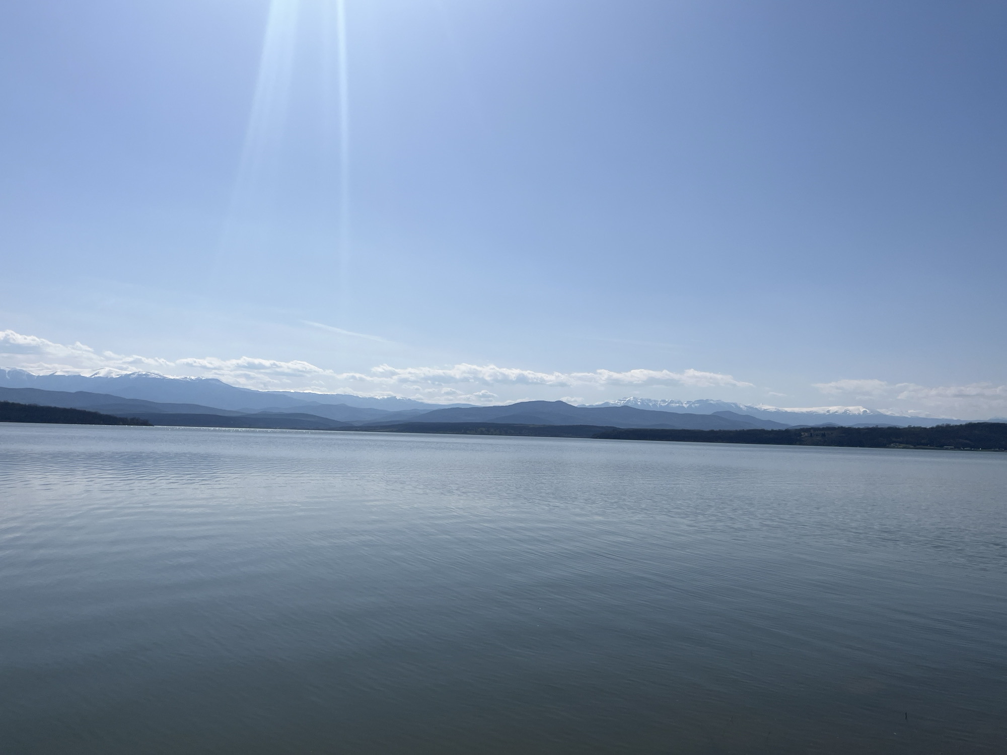 Young person kneels by lake in Montana, Bulgaria