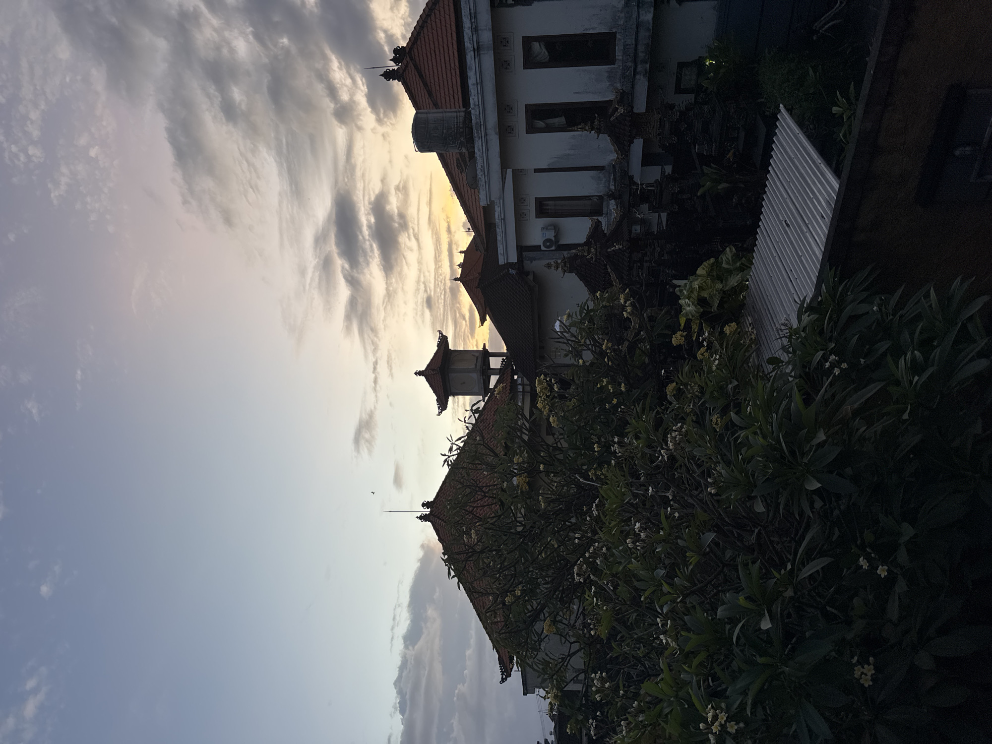 Traditional Balinese buildings captured under dramatic yellow-lit sky in Kuta