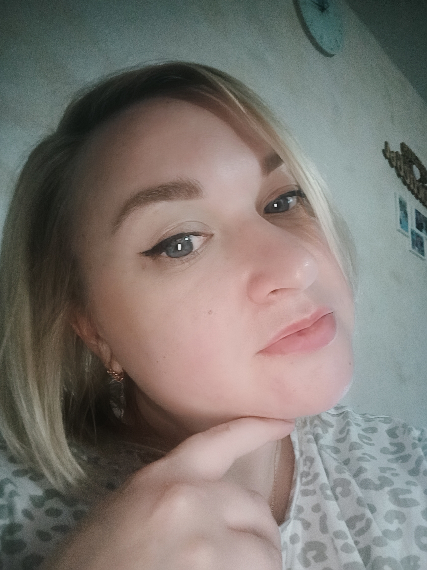 Blonde woman poses for multiple selfie shots indoors