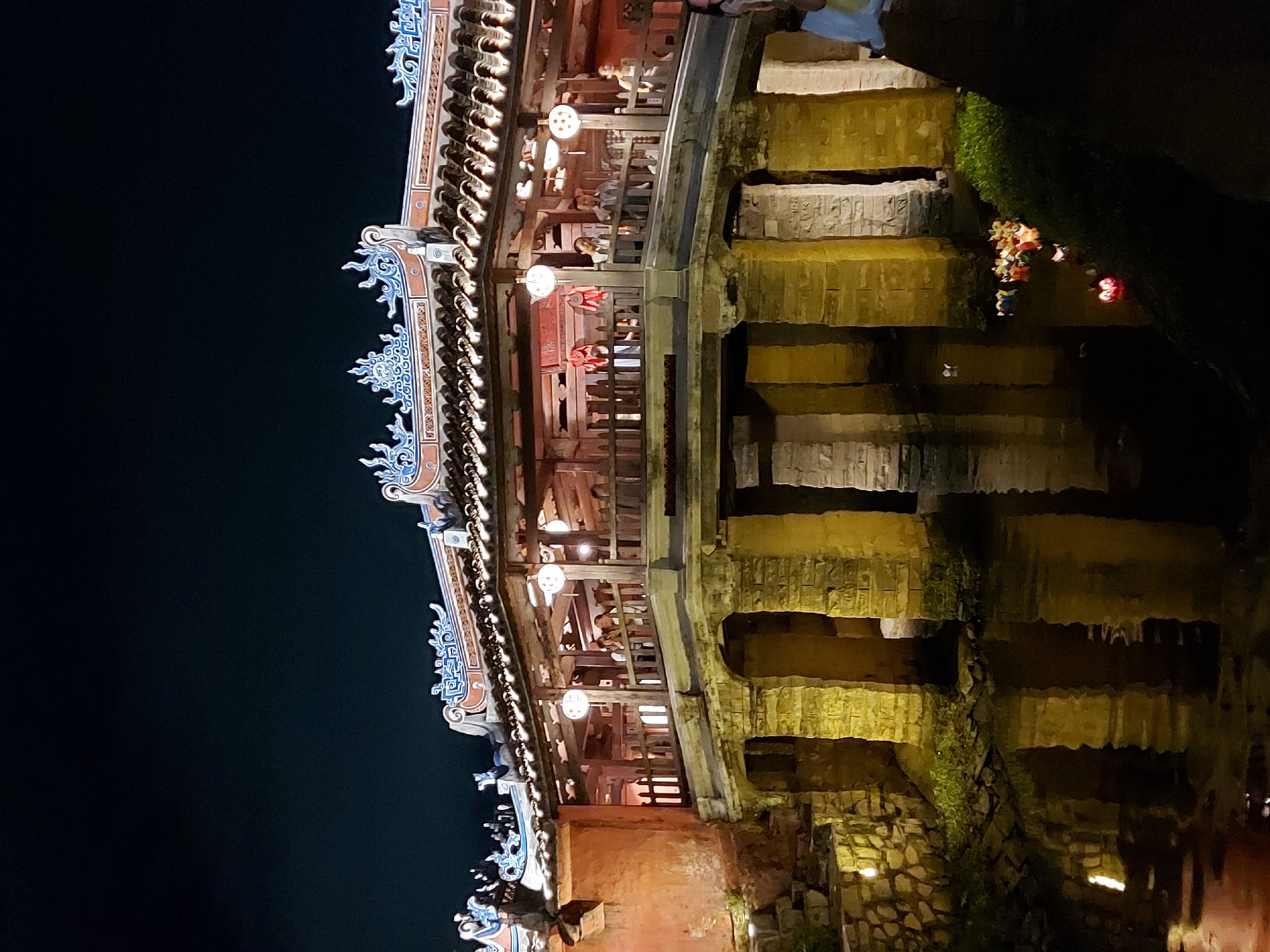 Hoi An's Japanese Covered Bridge glowing over the Thu Bon River at night