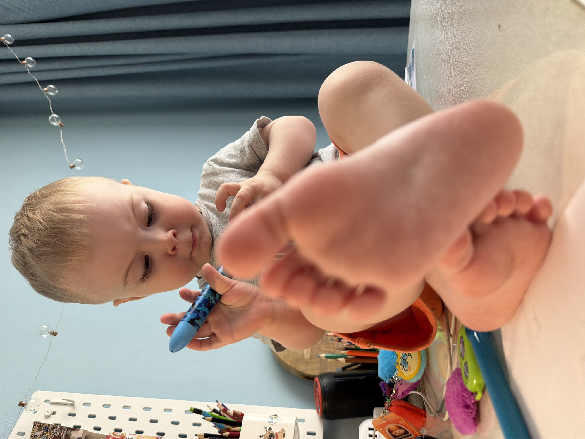 Toddler enjoys creative playtime with toys and drawing in Votkinsk
