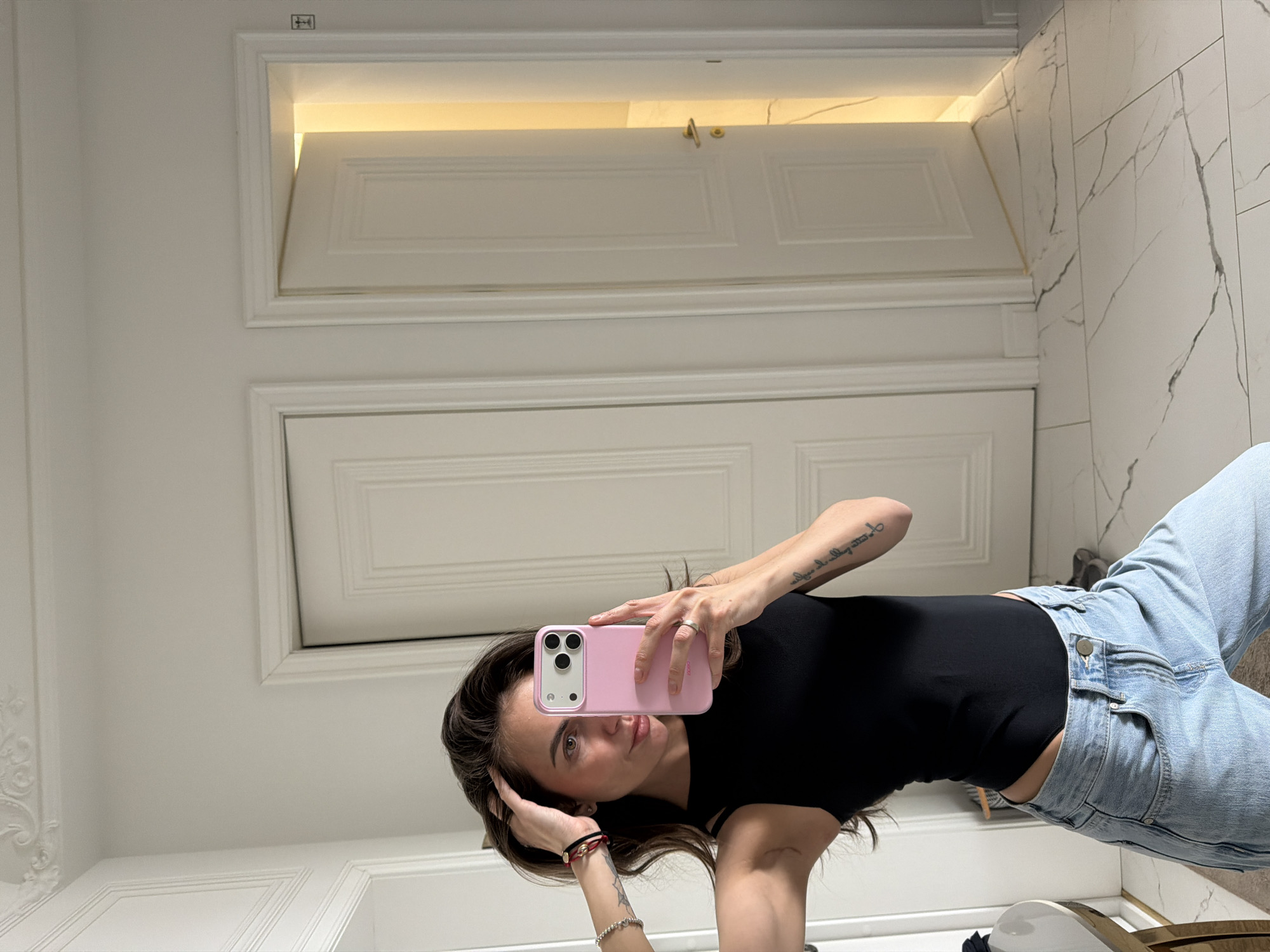 Woman takes mirror selfie with pink phone in Krasnoyarsk