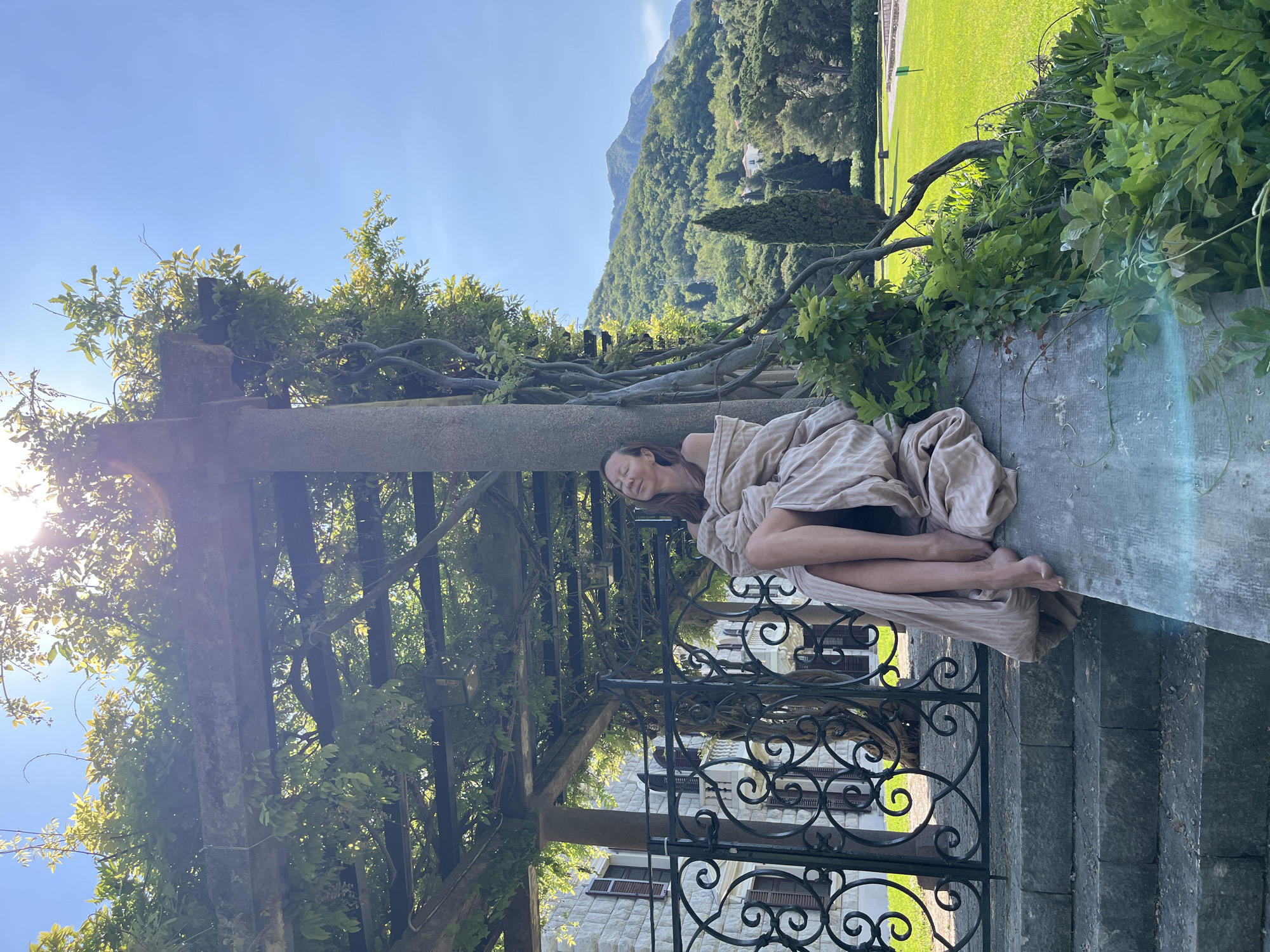 Woman rests in stone garden at Sveti Stefan