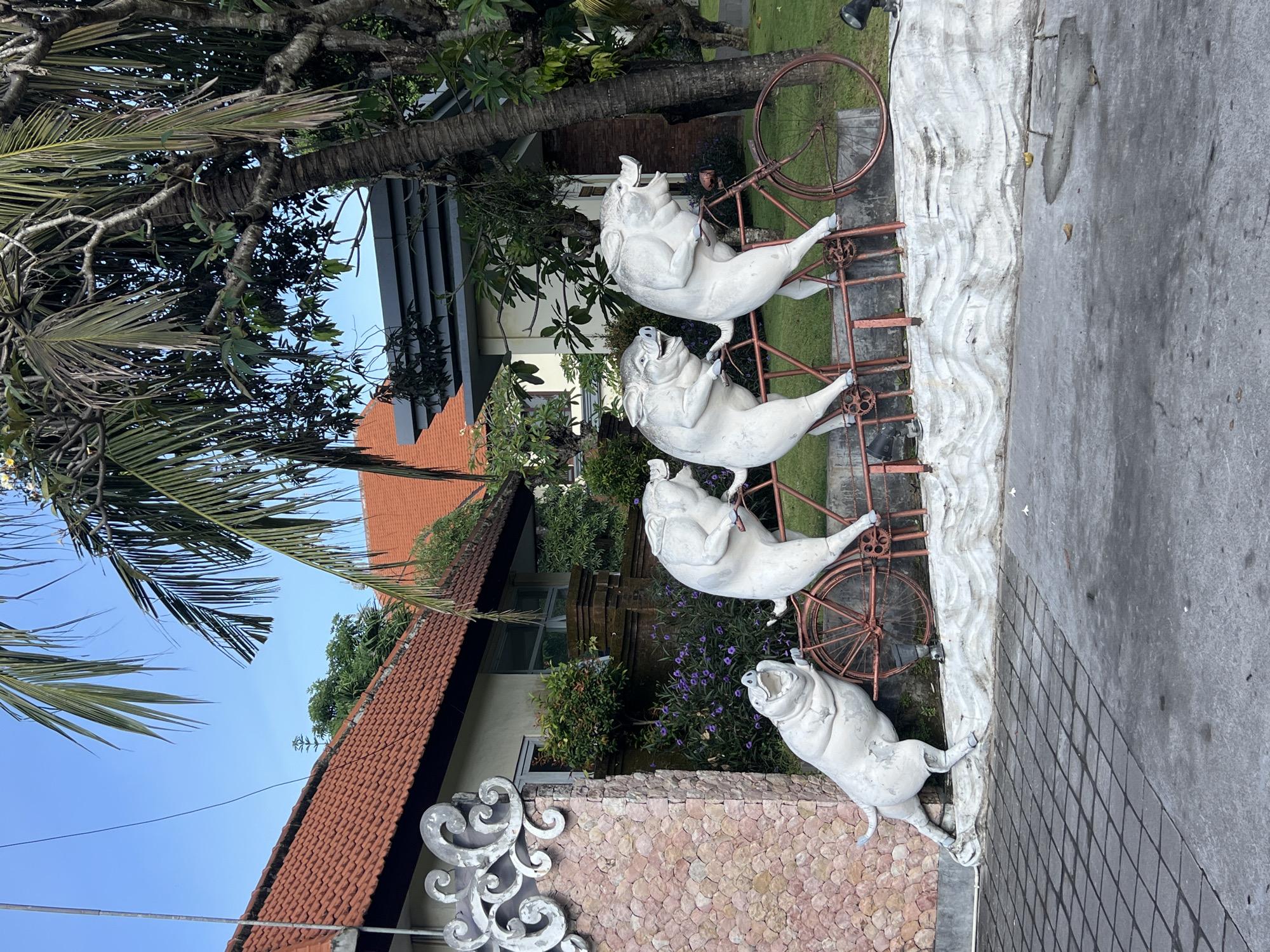 White sculpture garden featuring pigs, frog spotted in Sukawati