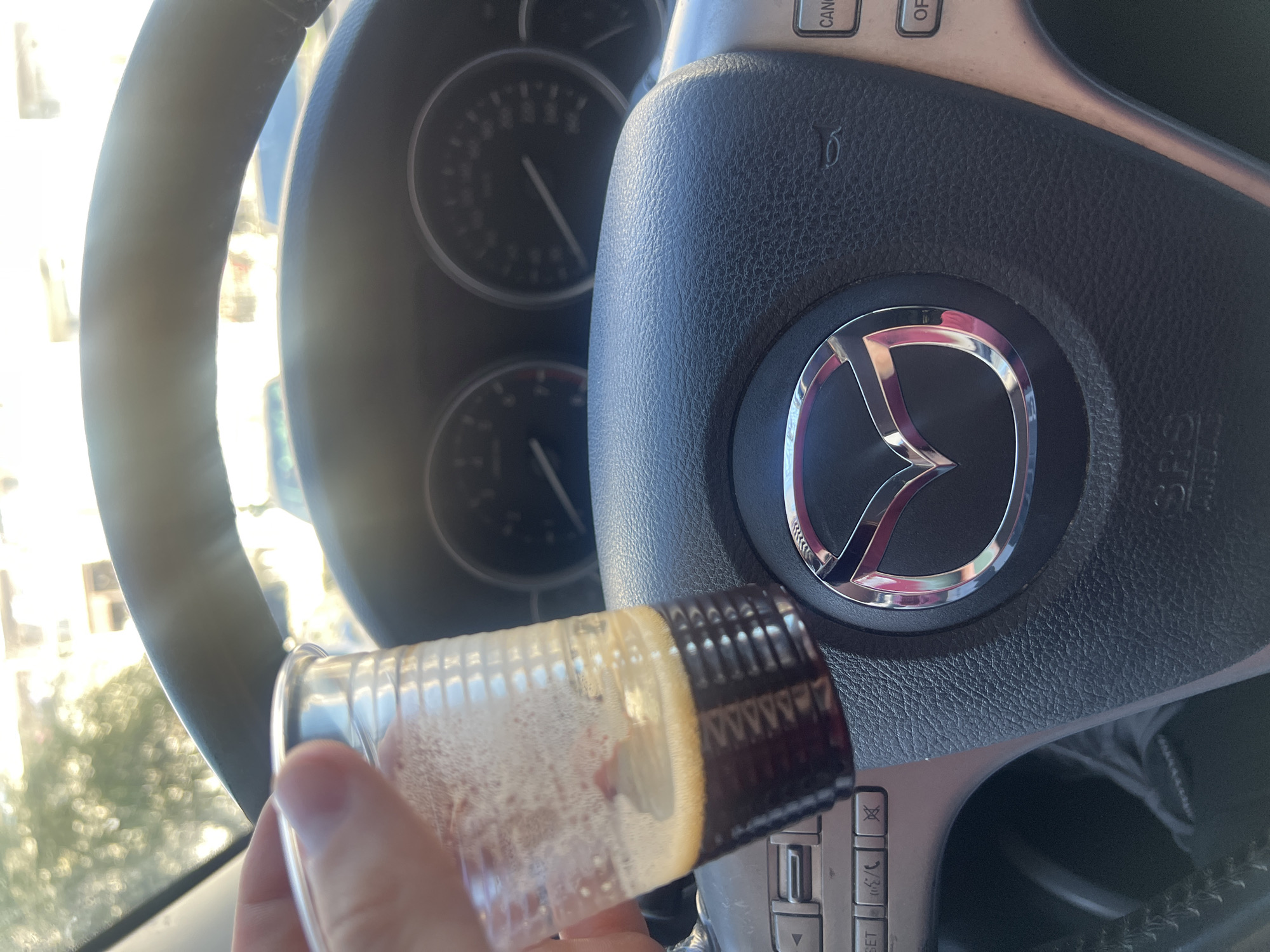 Driver holds drink in Mazda vehicle in Burgas