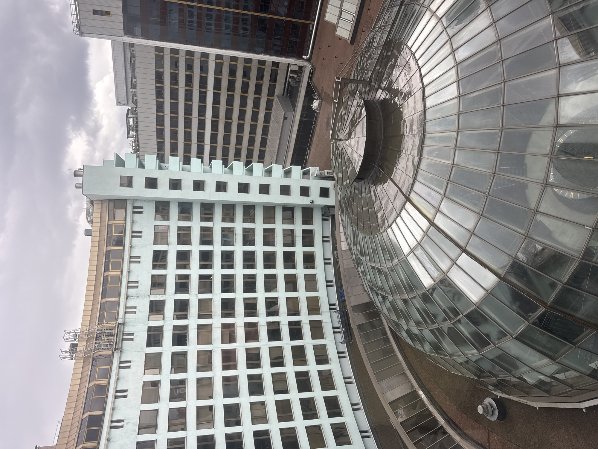 Geodesic glass dome rises above surrounding urban buildings