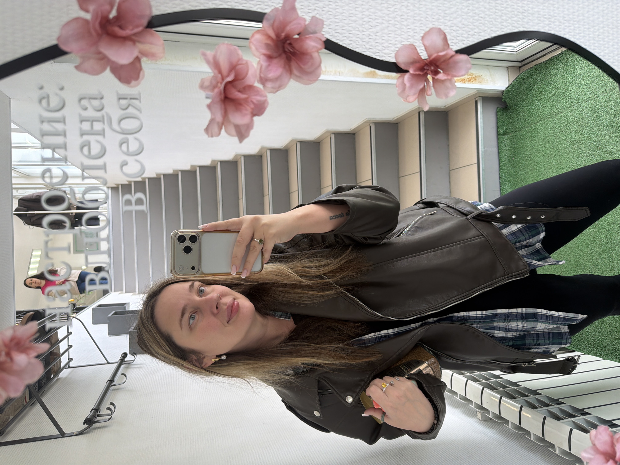Woman takes mirror selfie amid flowers in Chaikovsky, Russia