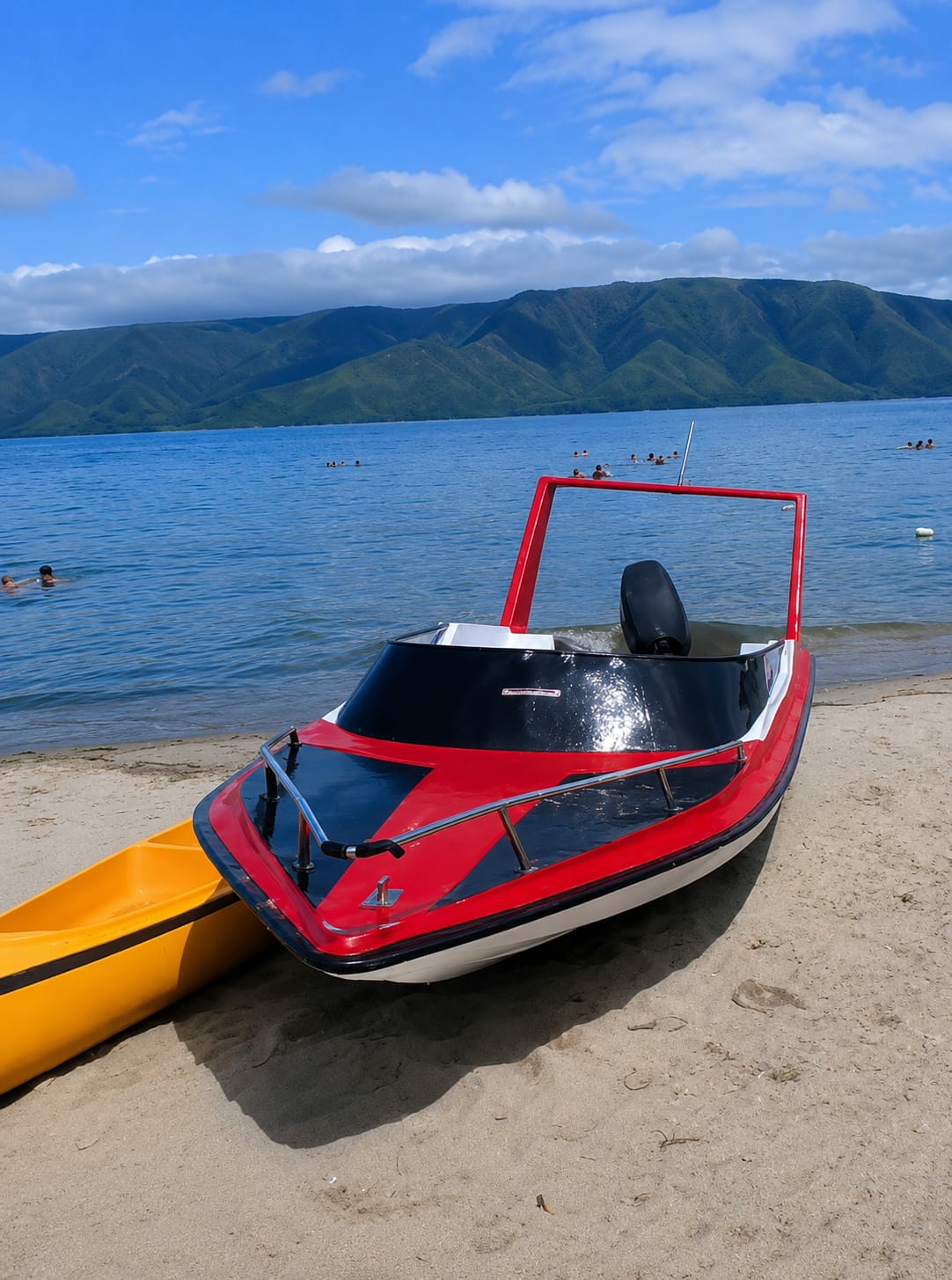 Lakeside beach day at Situngkir with boats and swimmers