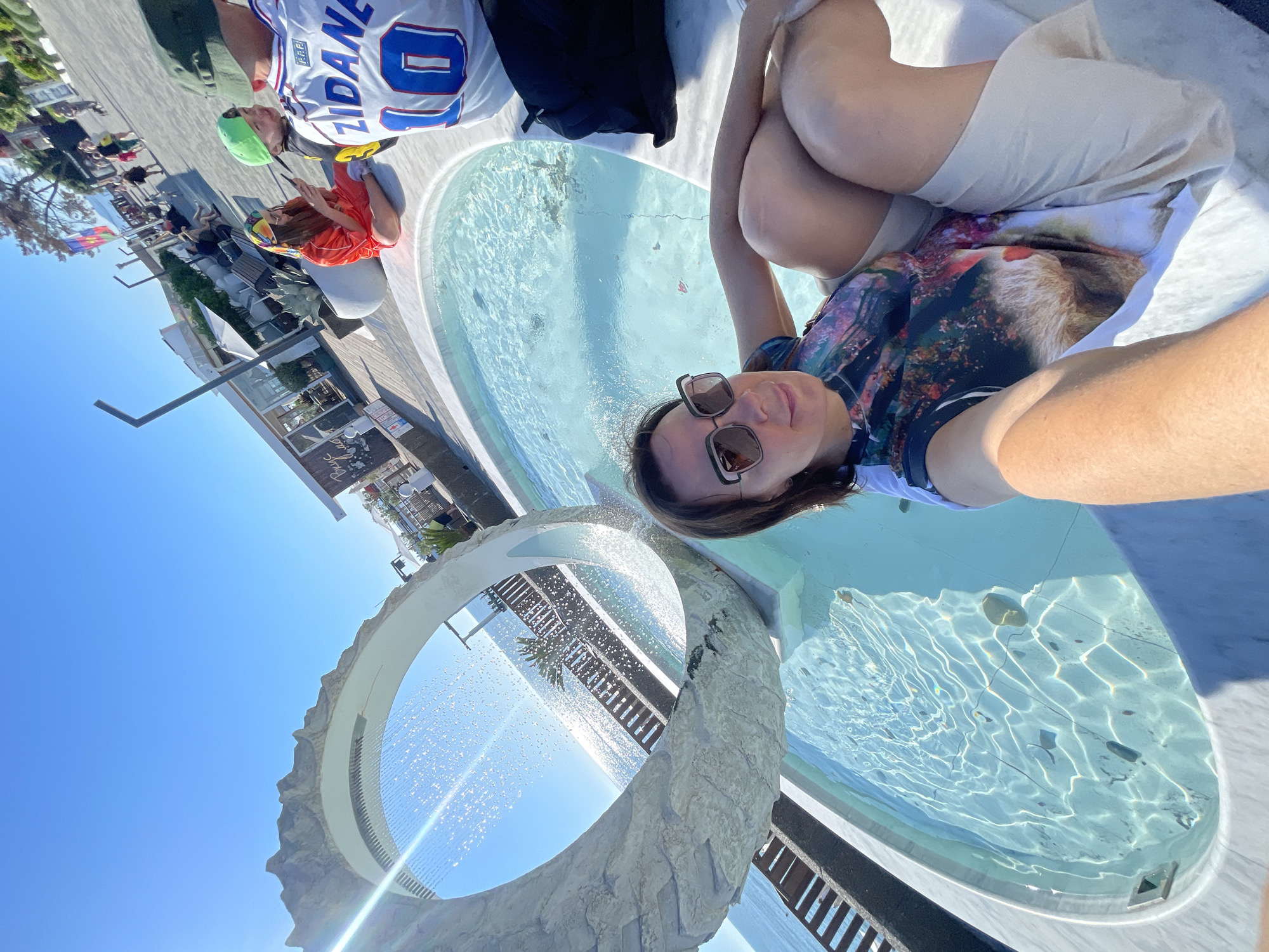 Woman enjoys sunny afternoon at Sochi waterfront cafes and fountains