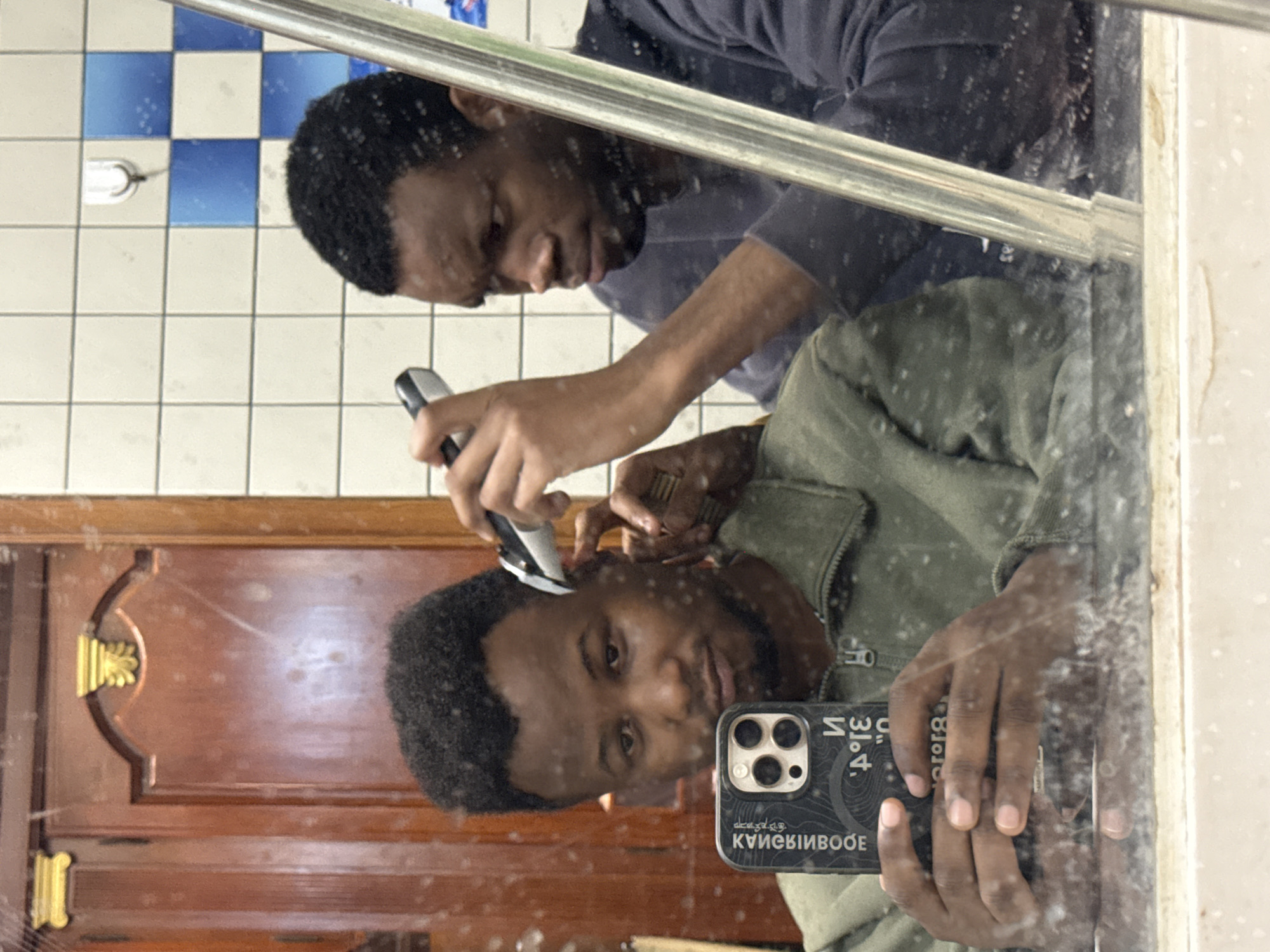 Friends give haircuts in Daxing District bathroom