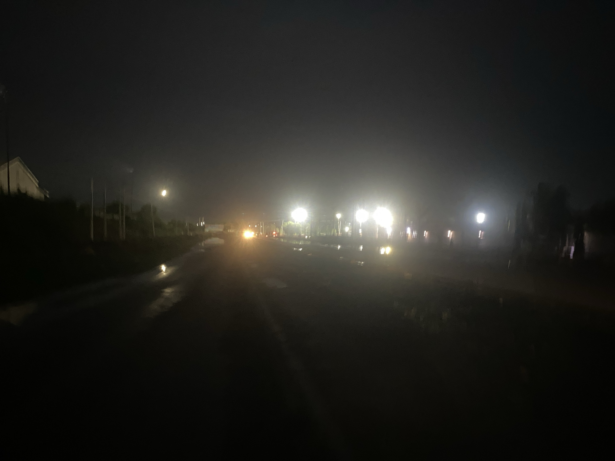 Overcast evening documented on wet road in Karmajiji, Nigeria