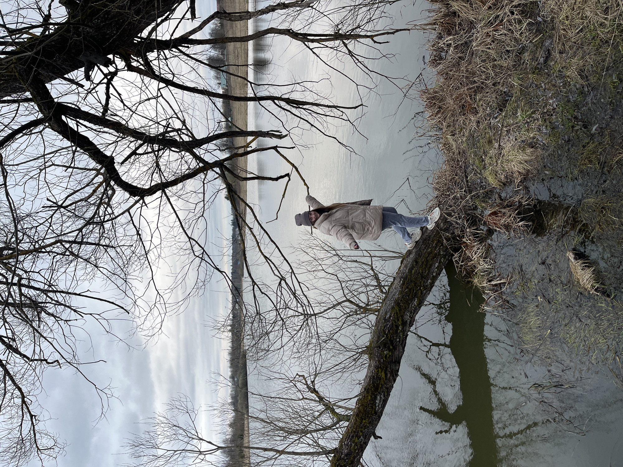 Woman photographs spring outing by water in Zolino, Russia