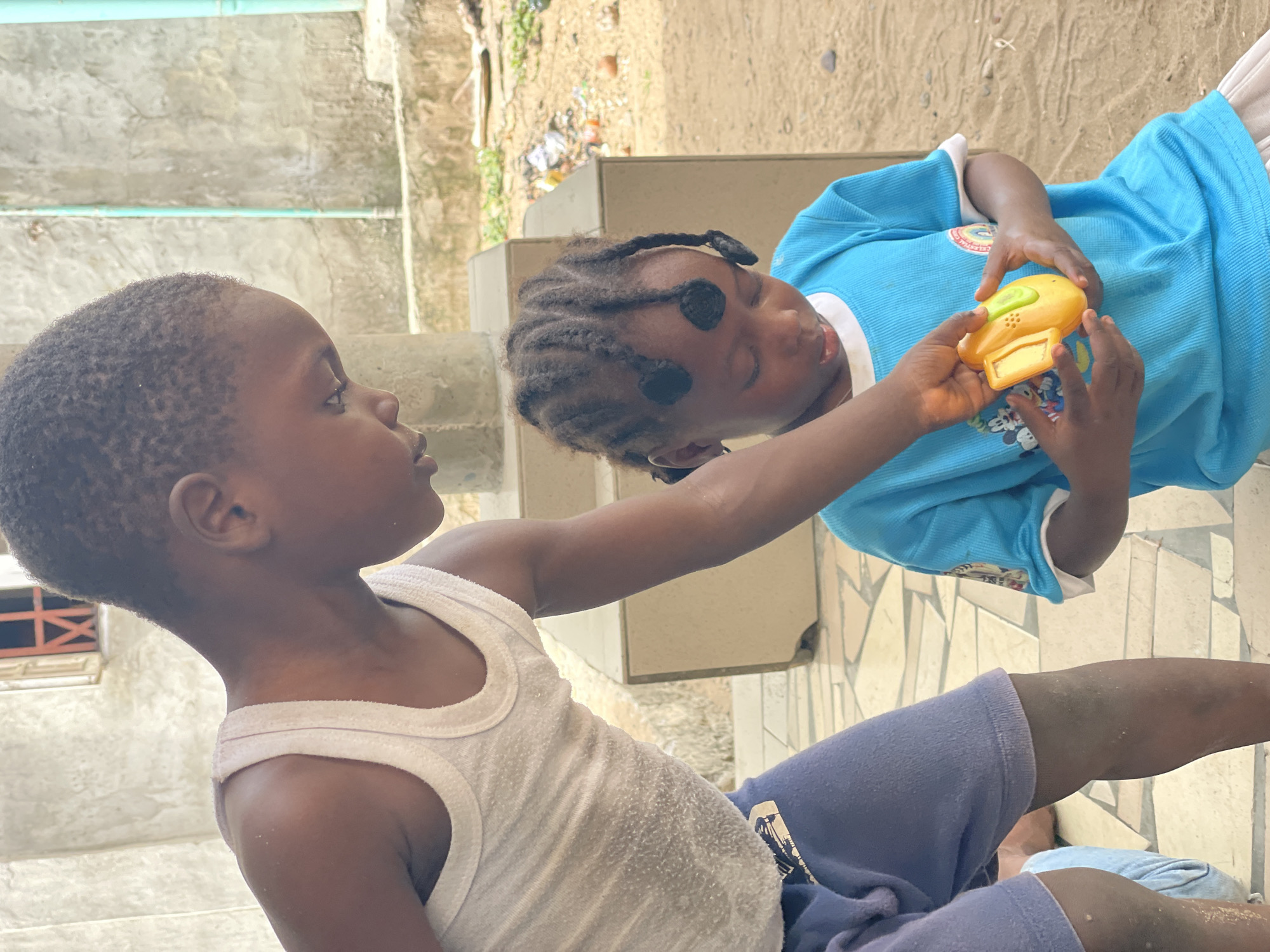 Children play with toys in courtyard, Badagry Nigeria
