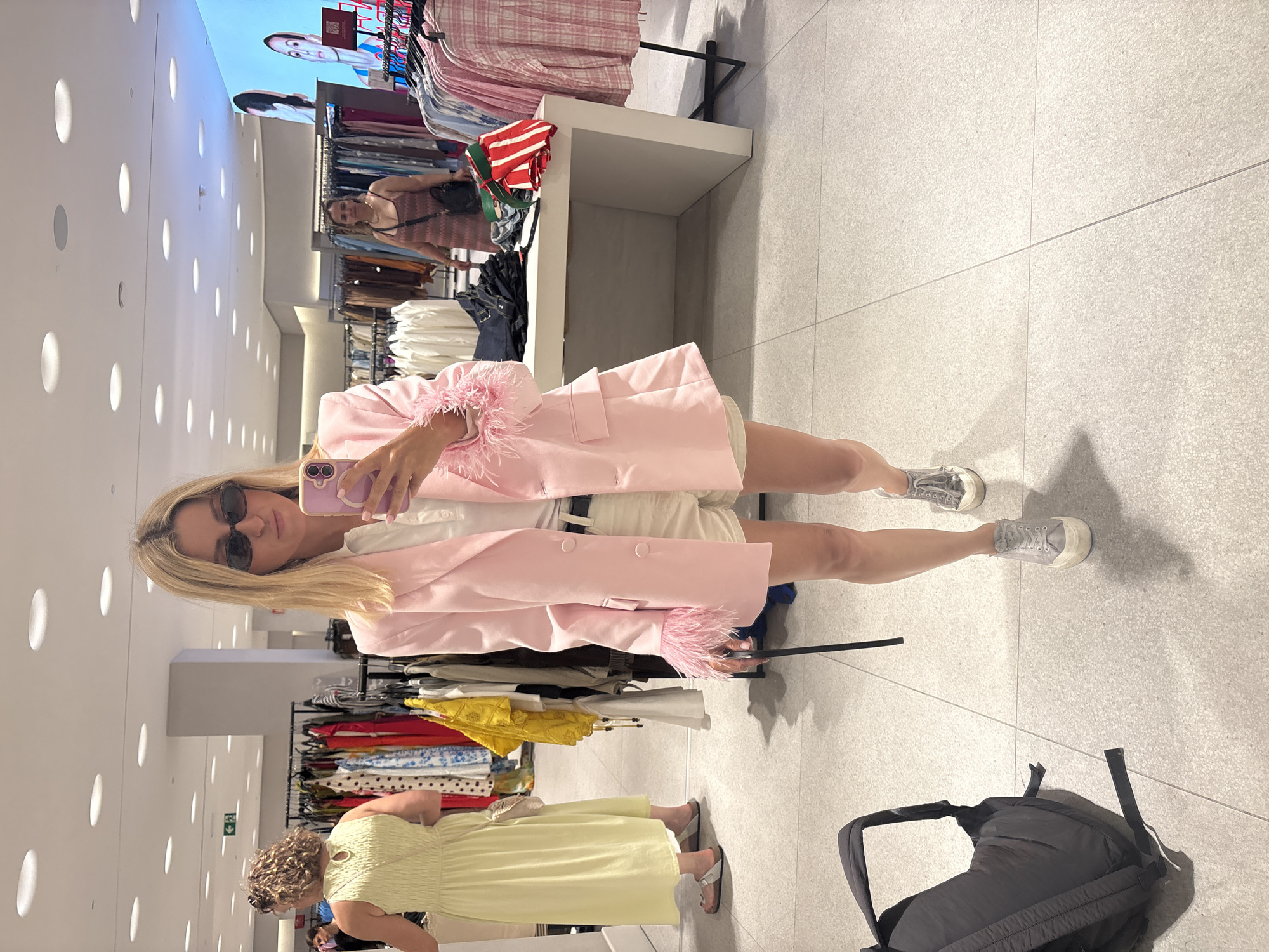 Trying on a feathered pink blazer in a Valencia boutique