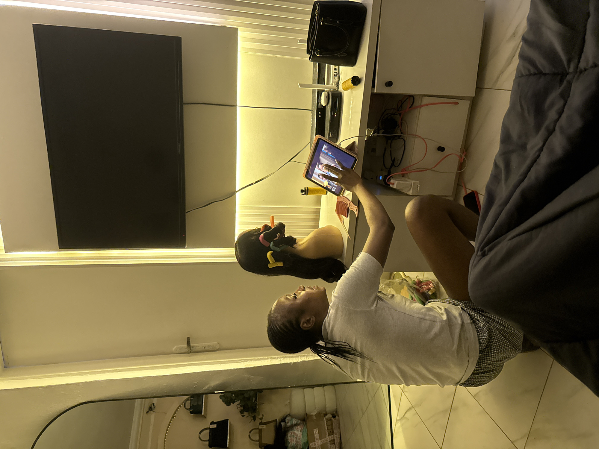 Quiet evening at home in Abuja with snacks, screens, and shelves