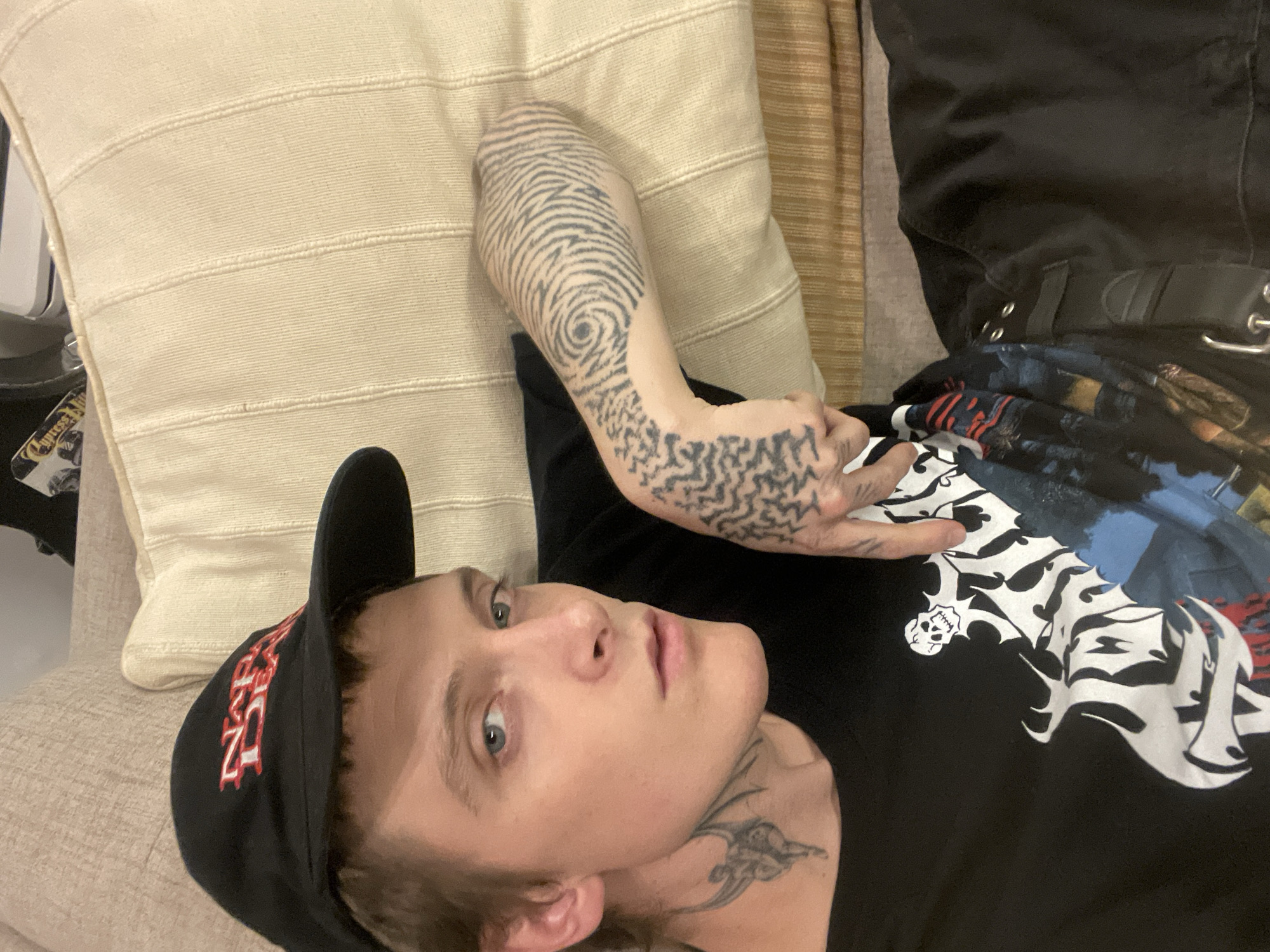 Person with tattoos rests on couch in Vicente López
