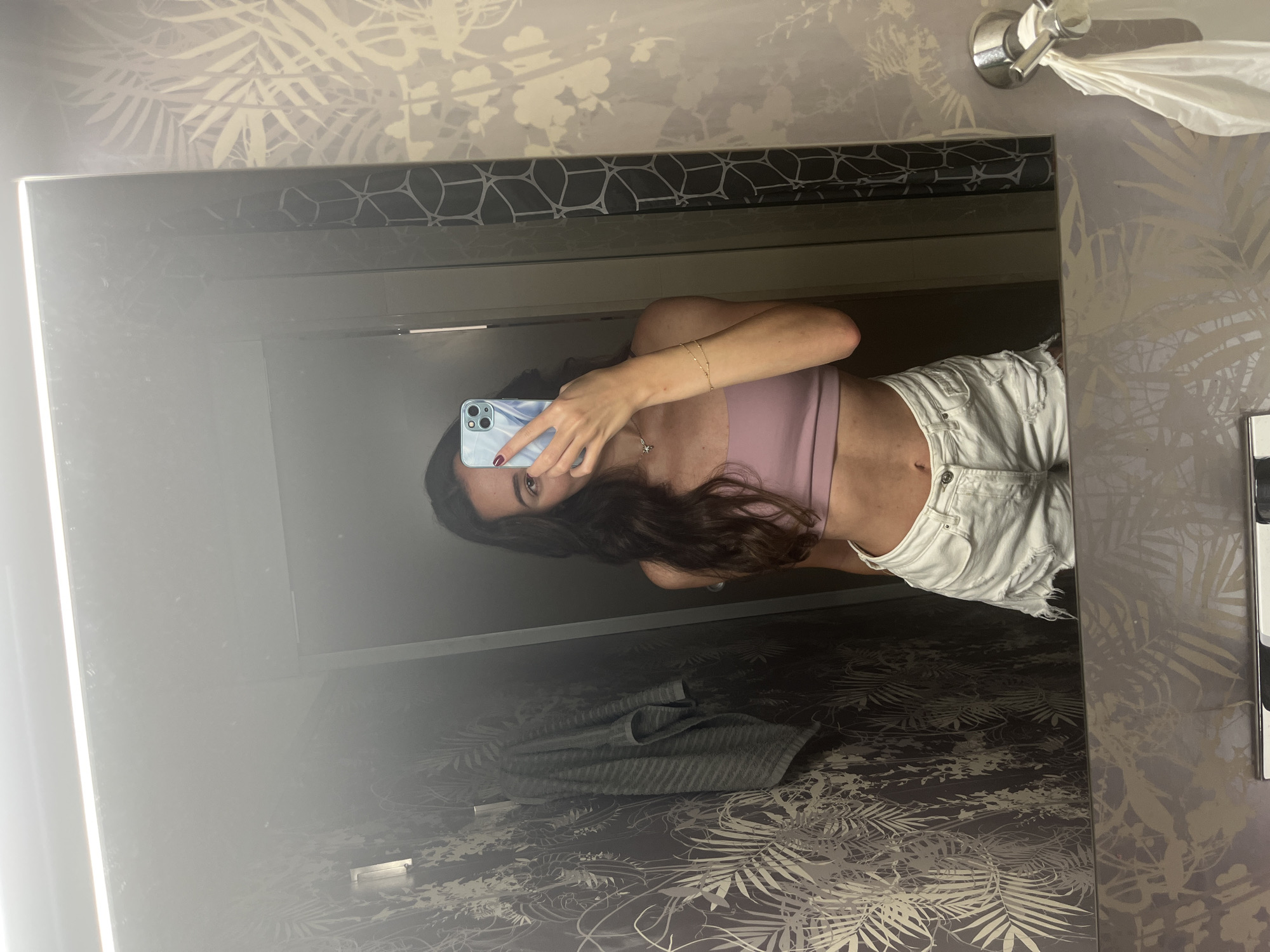 Woman takes bathroom mirror selfies in Alicante, Spain