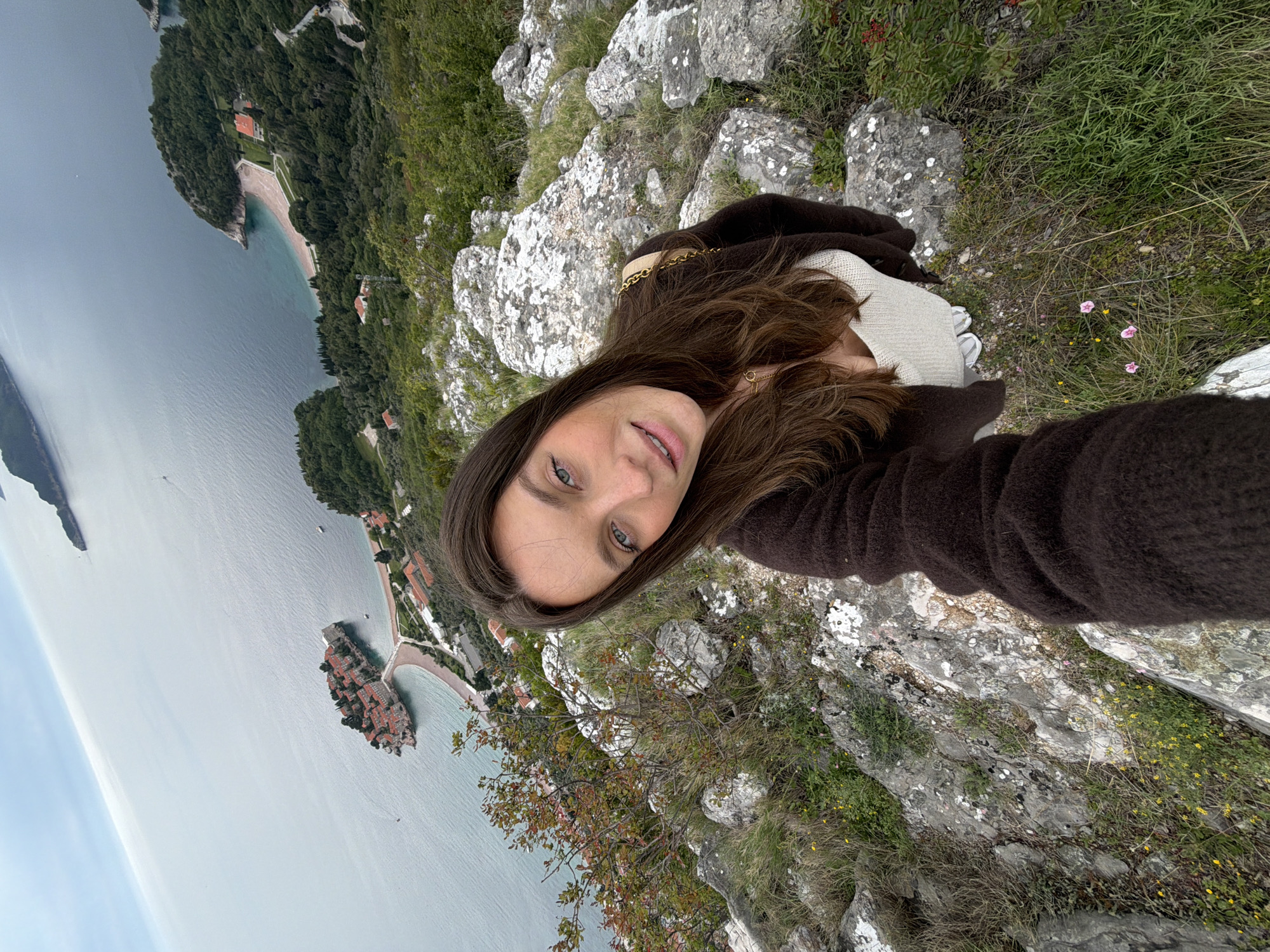 Woman takes selfie on rocks overlooking Adriatic in Montenegro